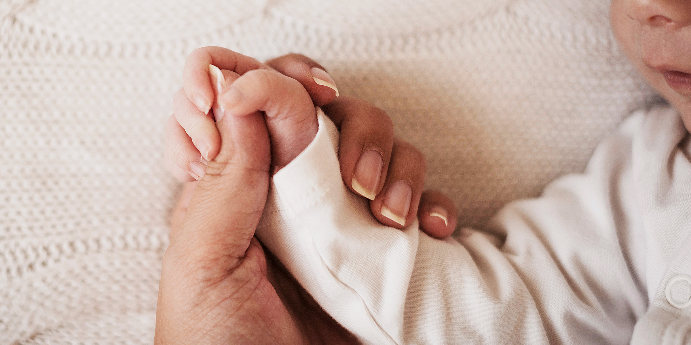 Une femme tenant la main d'un bébé | Source : Freepik