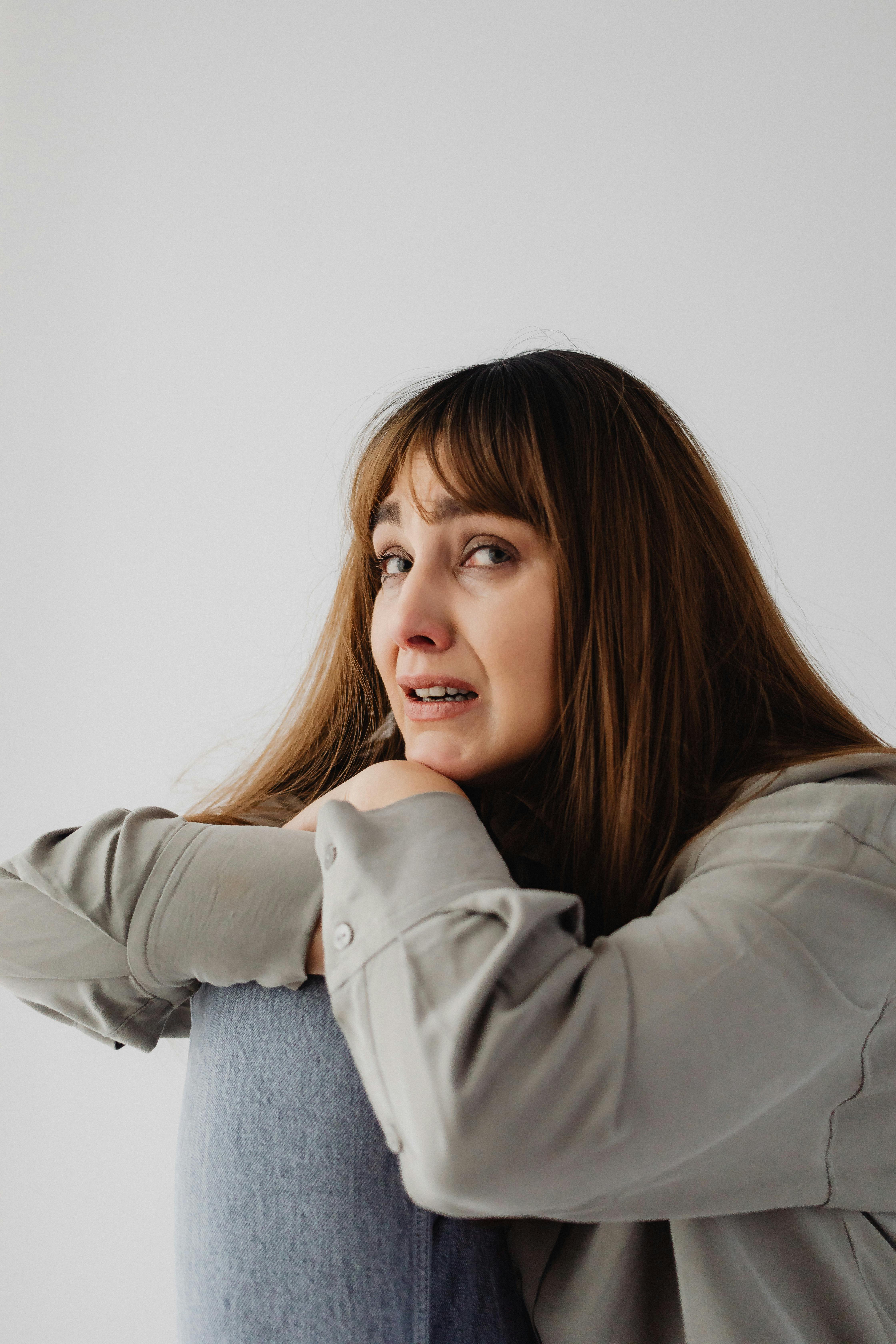 Une femme émotive appuyée sur une chaise | Source : Pexels