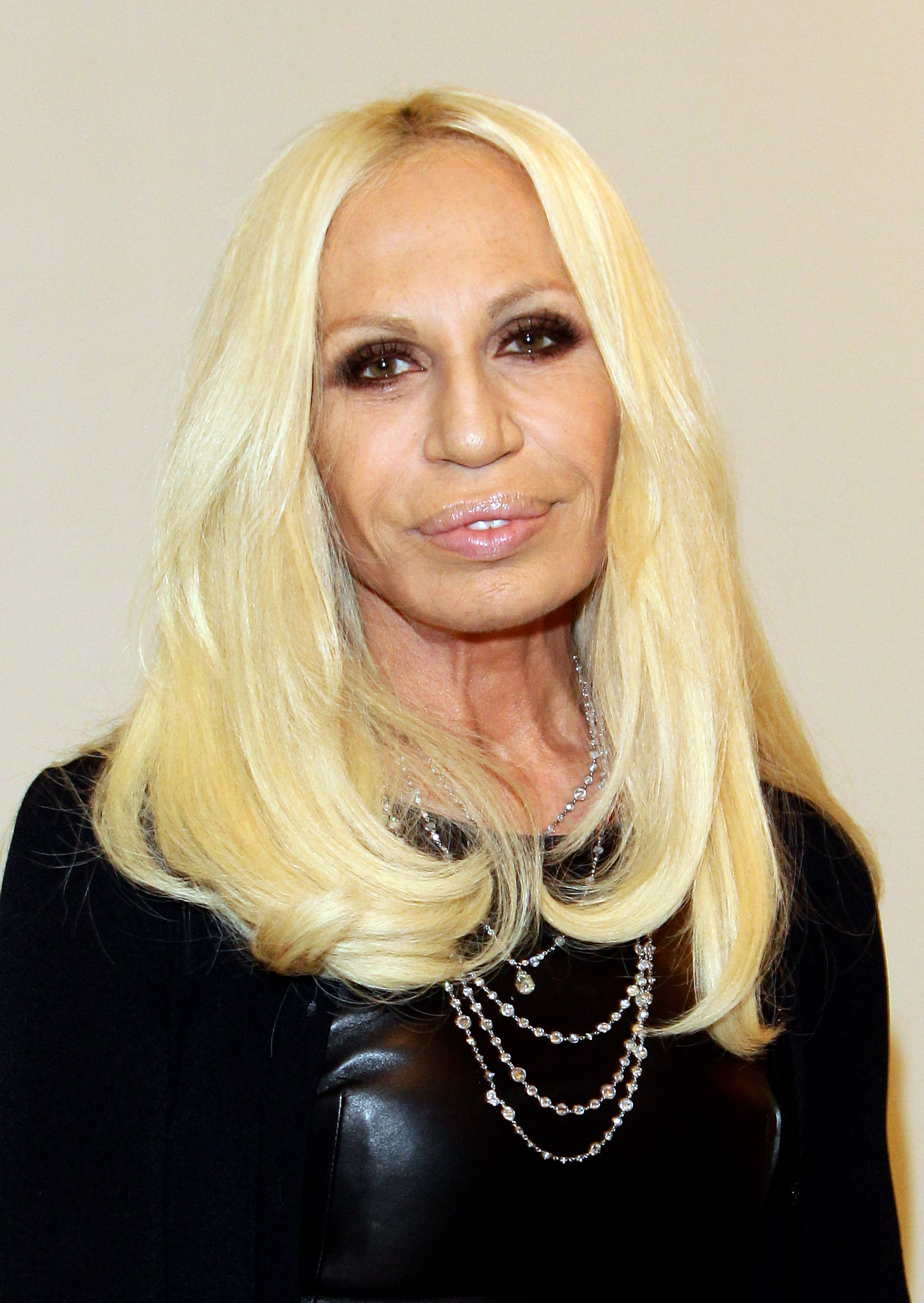 Donatella Versace, 55 ans, au lancement de « I Capricci Della Moda » le 10 décembre 2010 à Milan, en Italie. Son visage présentait de fines rides autour des yeux, des lèvres très pulpeuses et une peau uniformément tendue sur les joues.