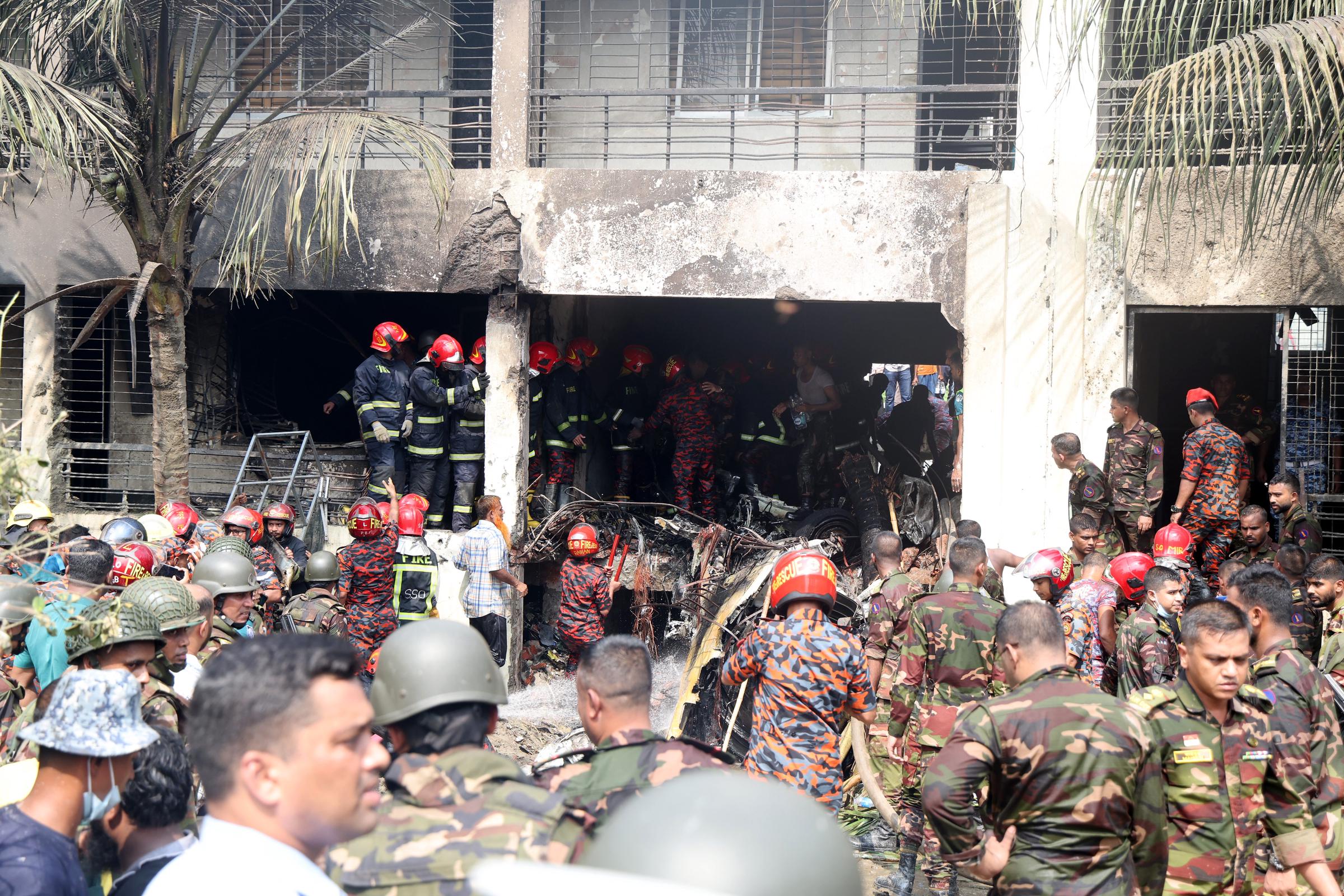 Des membres de l'armée bangladaise et des pompiers commencent les opérations de sauvetage après qu'un avion F7 de l'armée de l'air bangladaise s'est écrasé sur un bâtiment du Milestone College à Uttara, à Dhaka, au Bangladesh, le 21 juillet 2025 | Source : Getty Images