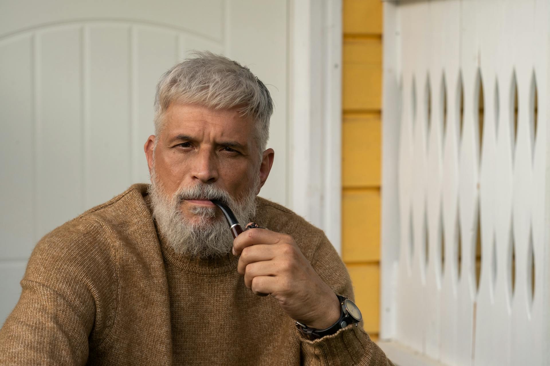 Un homme assis sous le porche avec une pipe | Source : Pexels
