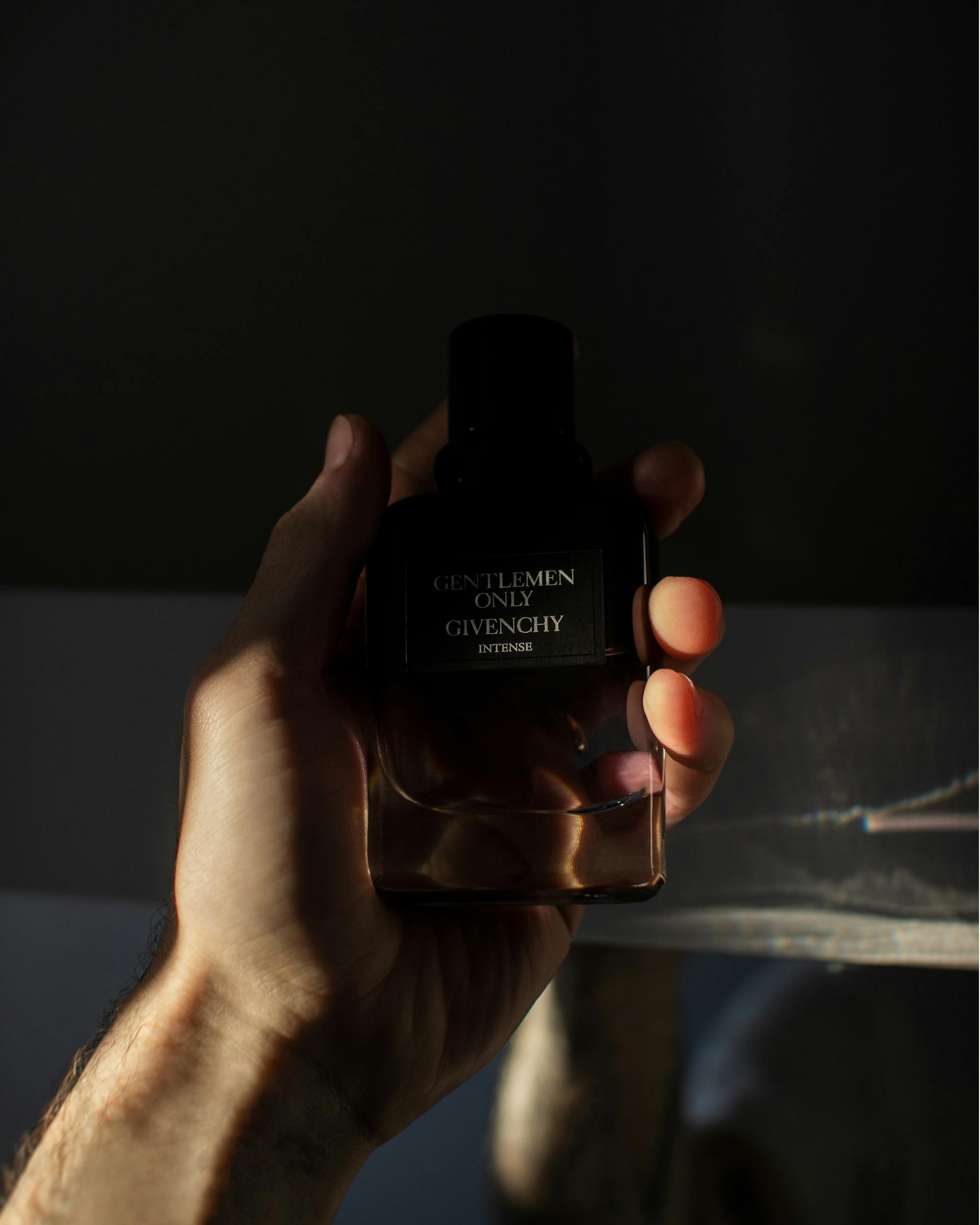 Gros plan sur un homme tenant un flacon de parfum | Source : Pexels