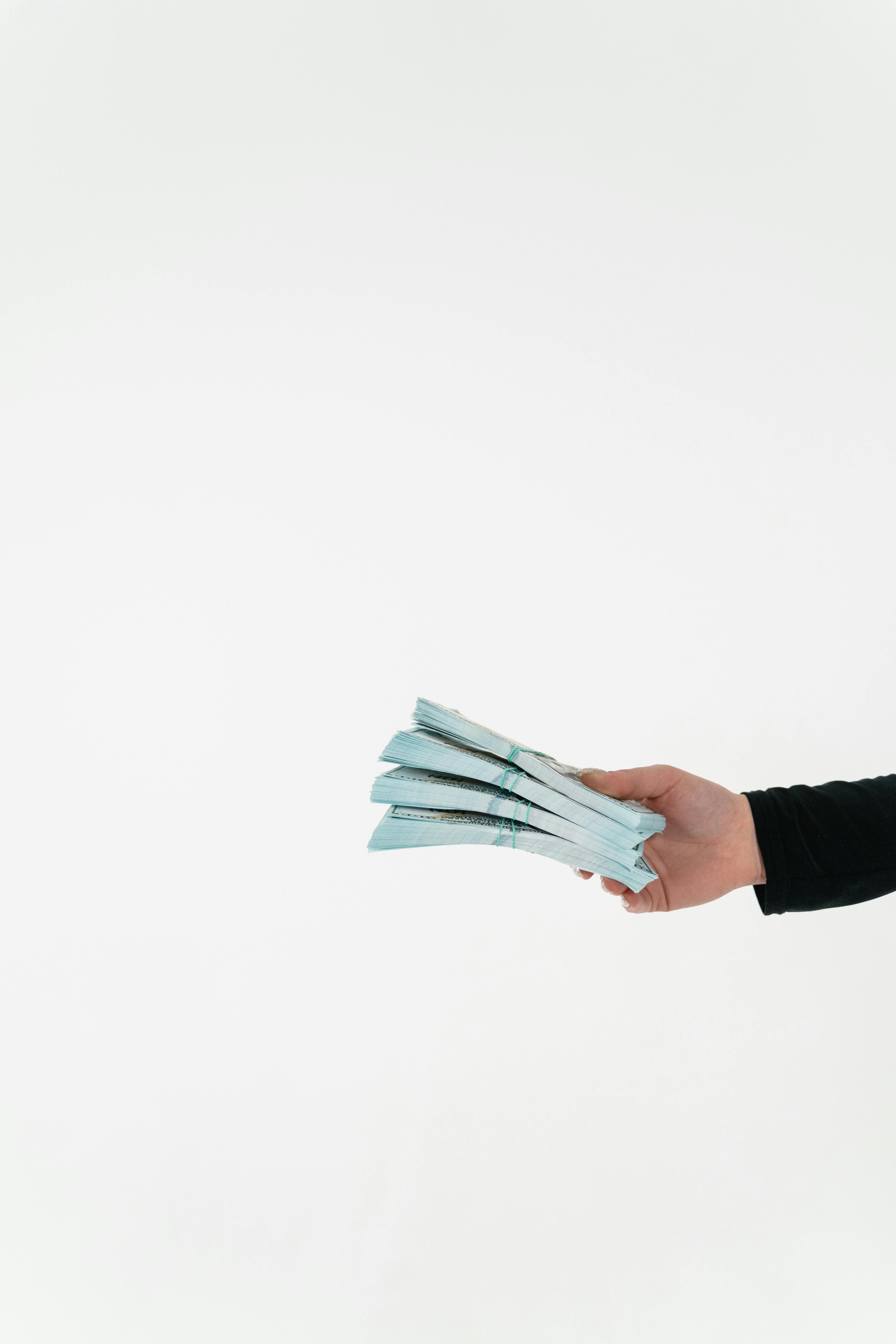Une personne tenant des liasses de billets | Source : Pexels