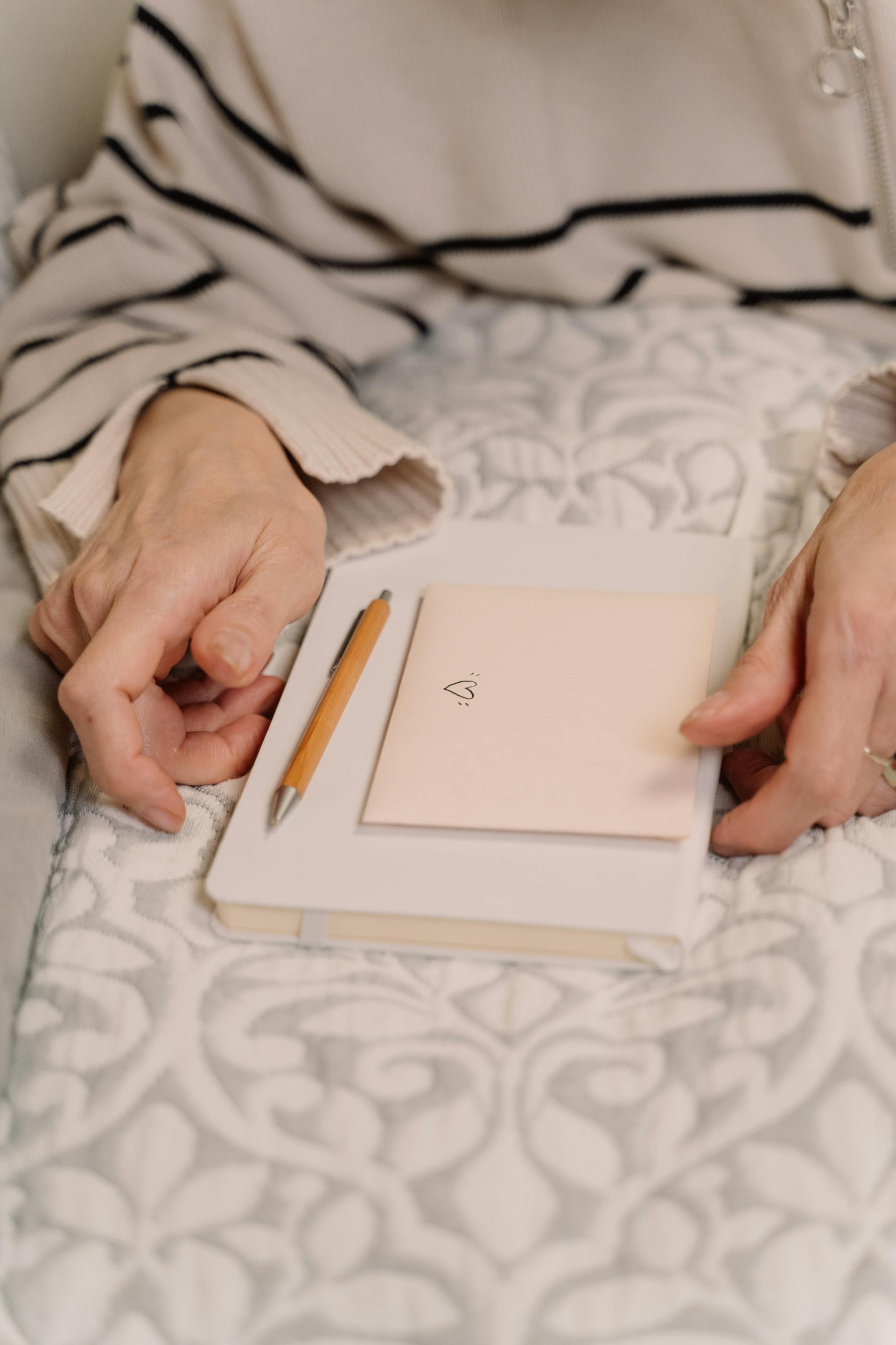 Gros plan d'une femme tenant un journal intime et une enveloppe | Source : Pexels