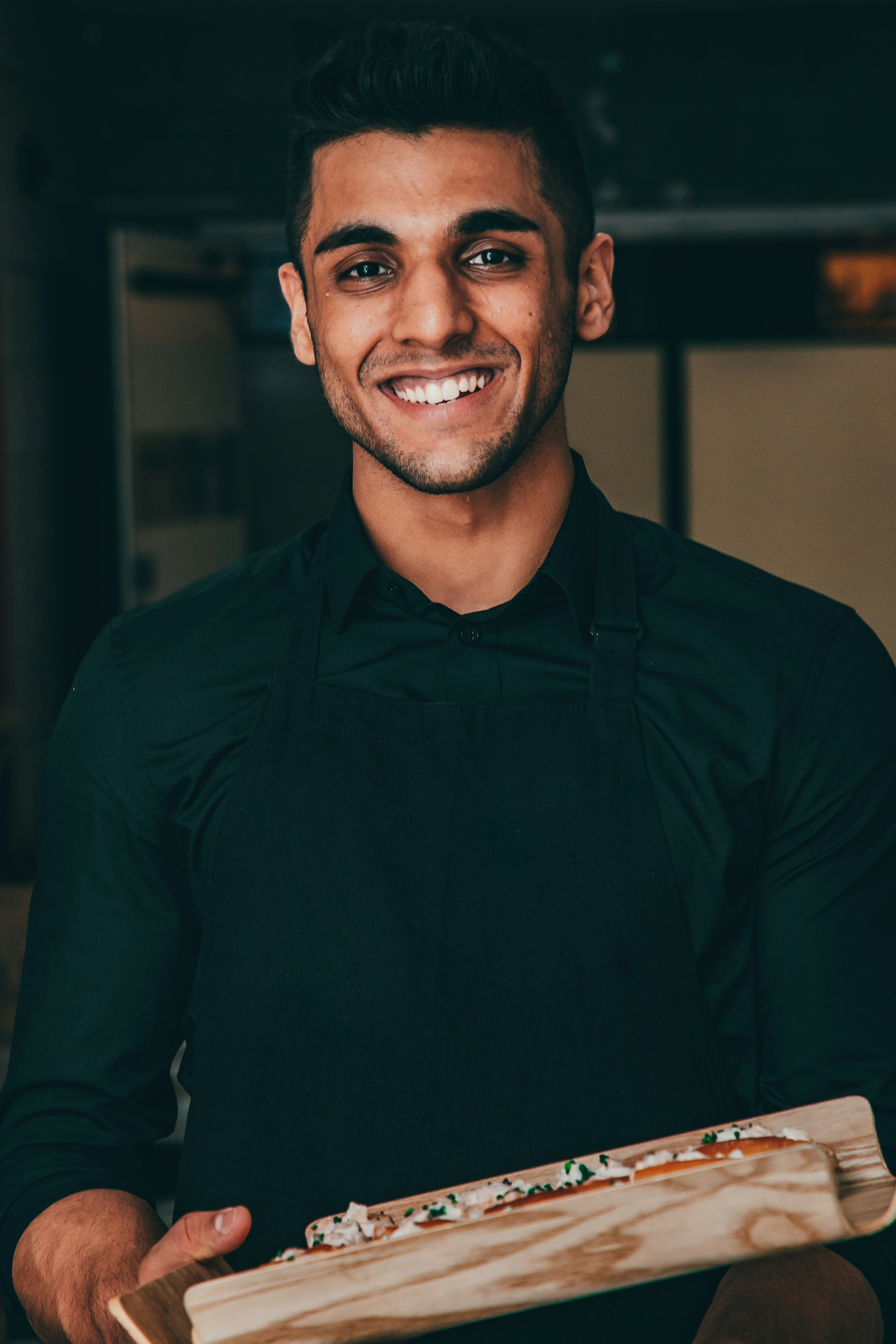 Un jeune serveur souriant | Source : Unsplash