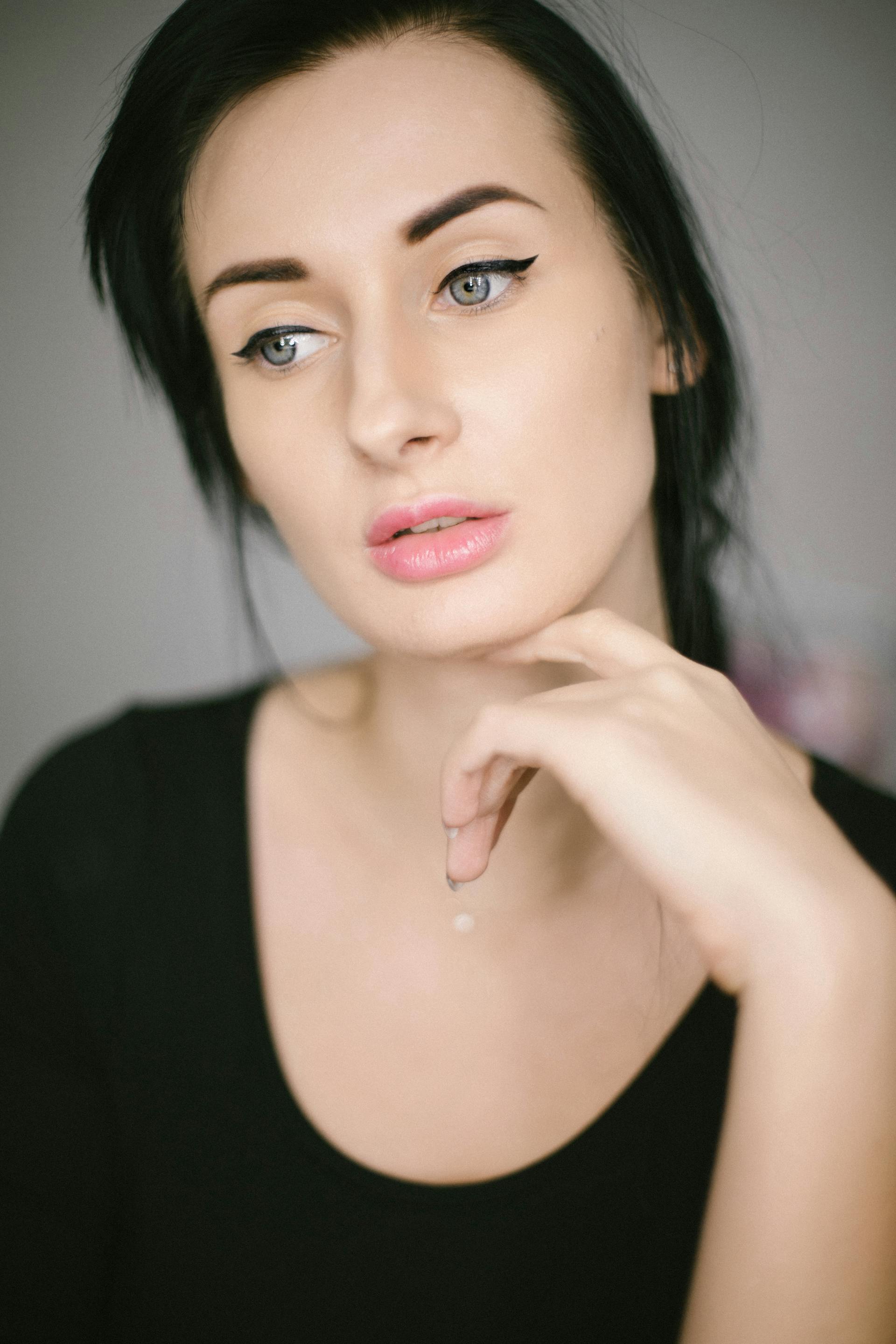 Une femme aux cheveux bruns en pleine réflexion | Source : Pexels