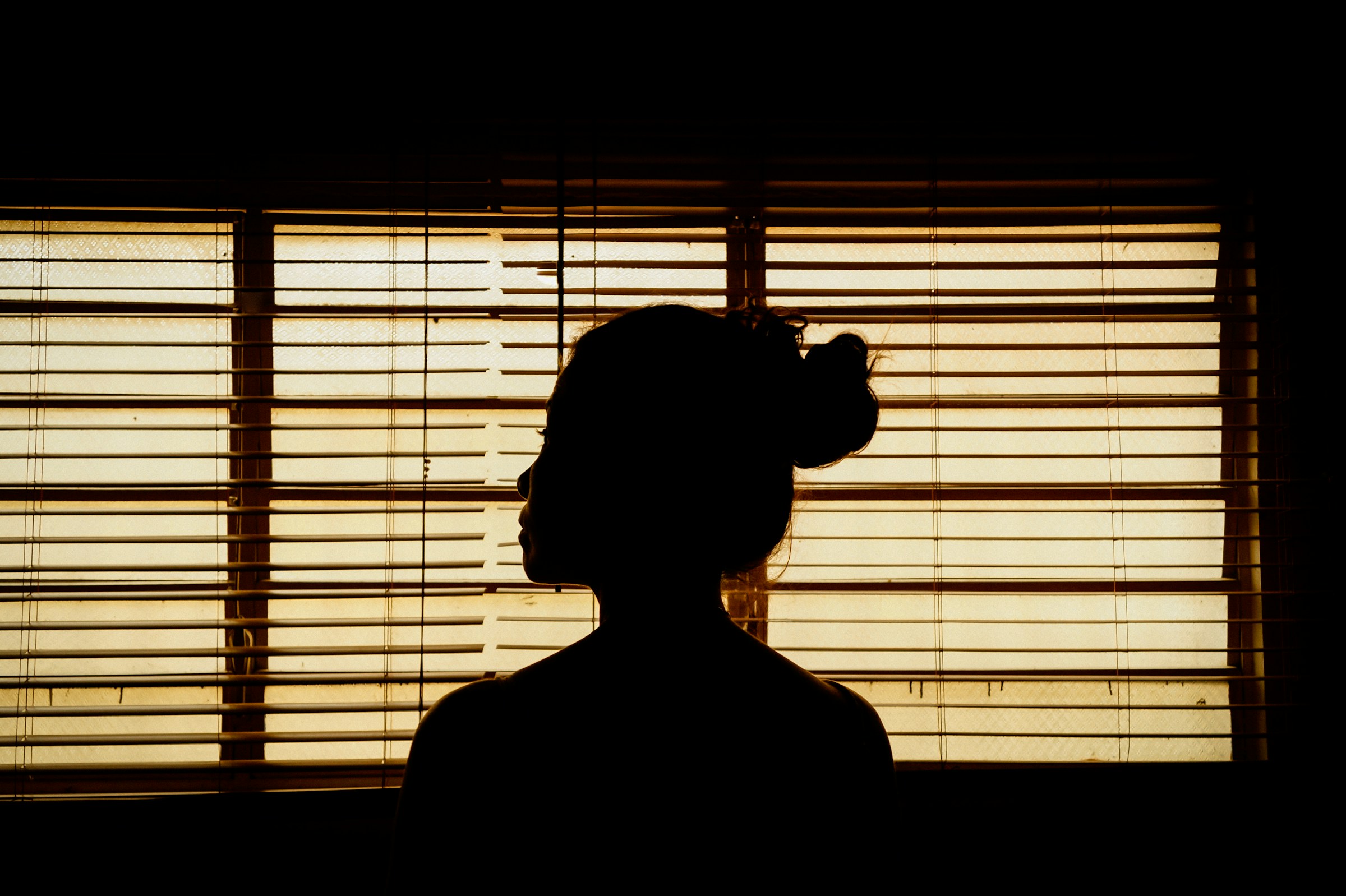 Une personne se cachant derrière des stores | Source : Unsplash
