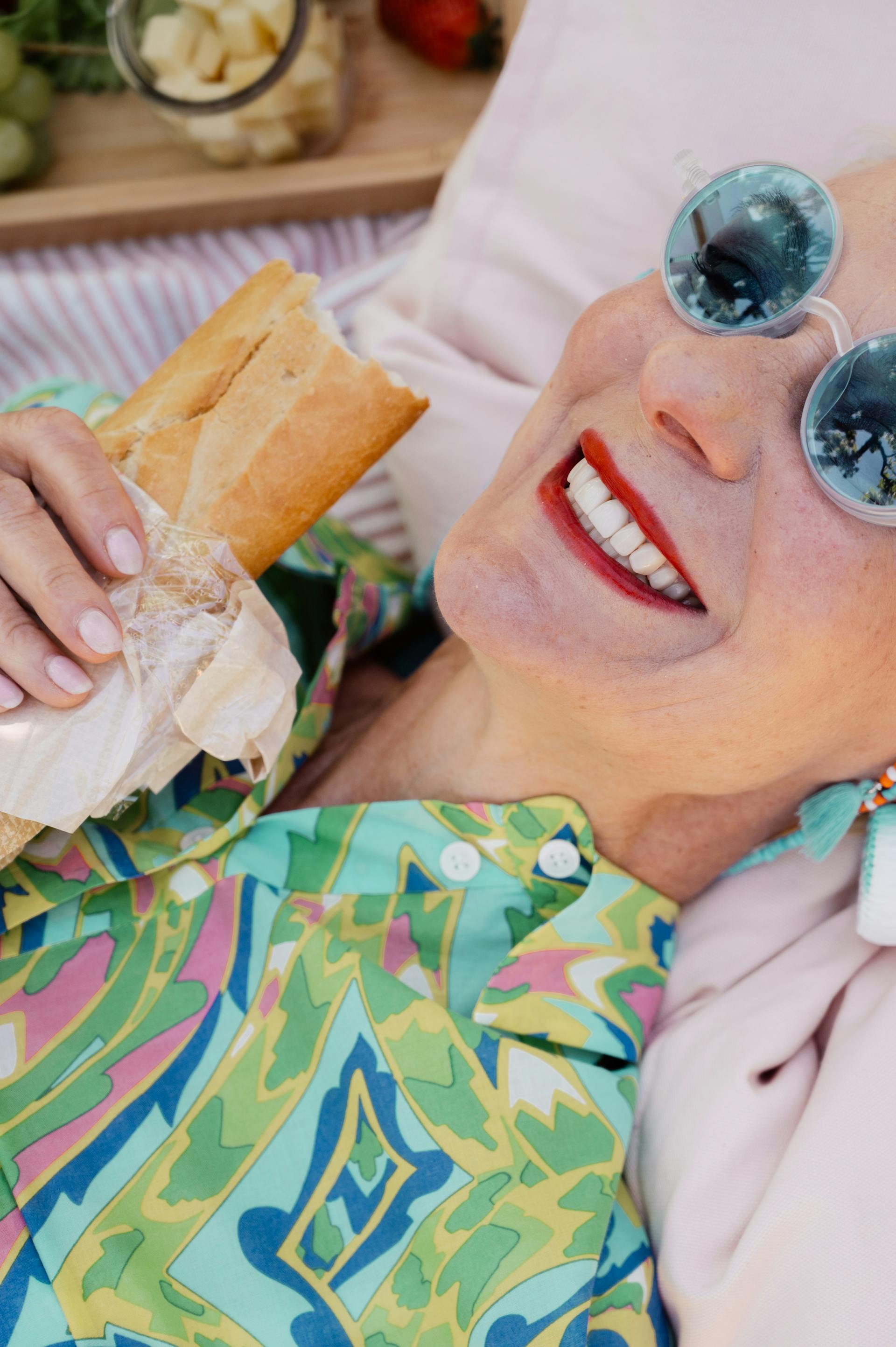 Gros plan sur une femme âgée allongée qui tient un hamburger | Source : Pexels