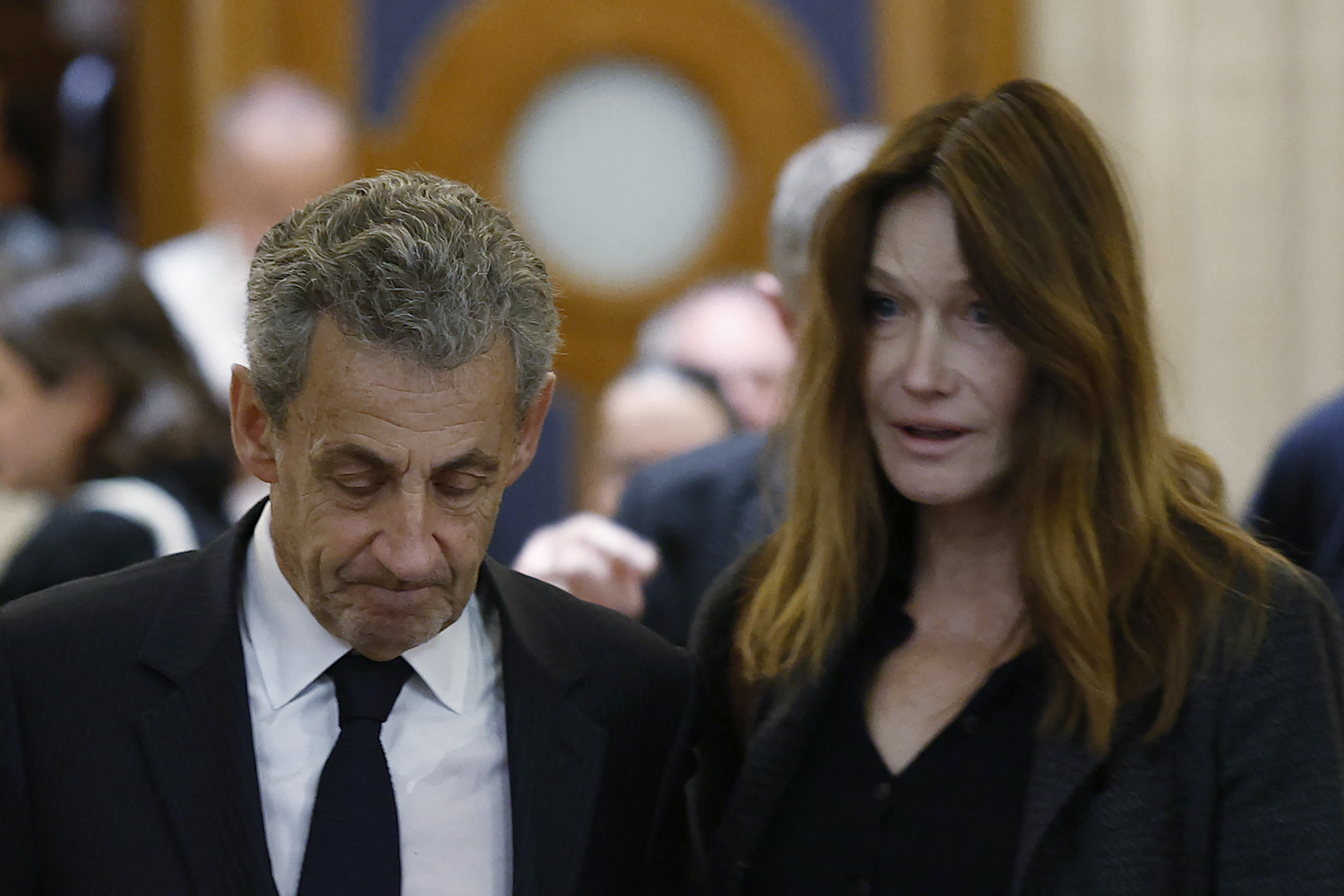 L'ancien président français Nicolas Sarkozy (à gauche) et son épouse Carla Bruni-Sarkozy quittent la salle d'audience après une suspension d'audience lors de son procès en appel concernant les accusations selon lesquelles il aurait sollicité un financement libyen pour sa campagne électorale de 2007, au Palais de Justice de Paris, le 7 avril 2026 I Source : Getty Images