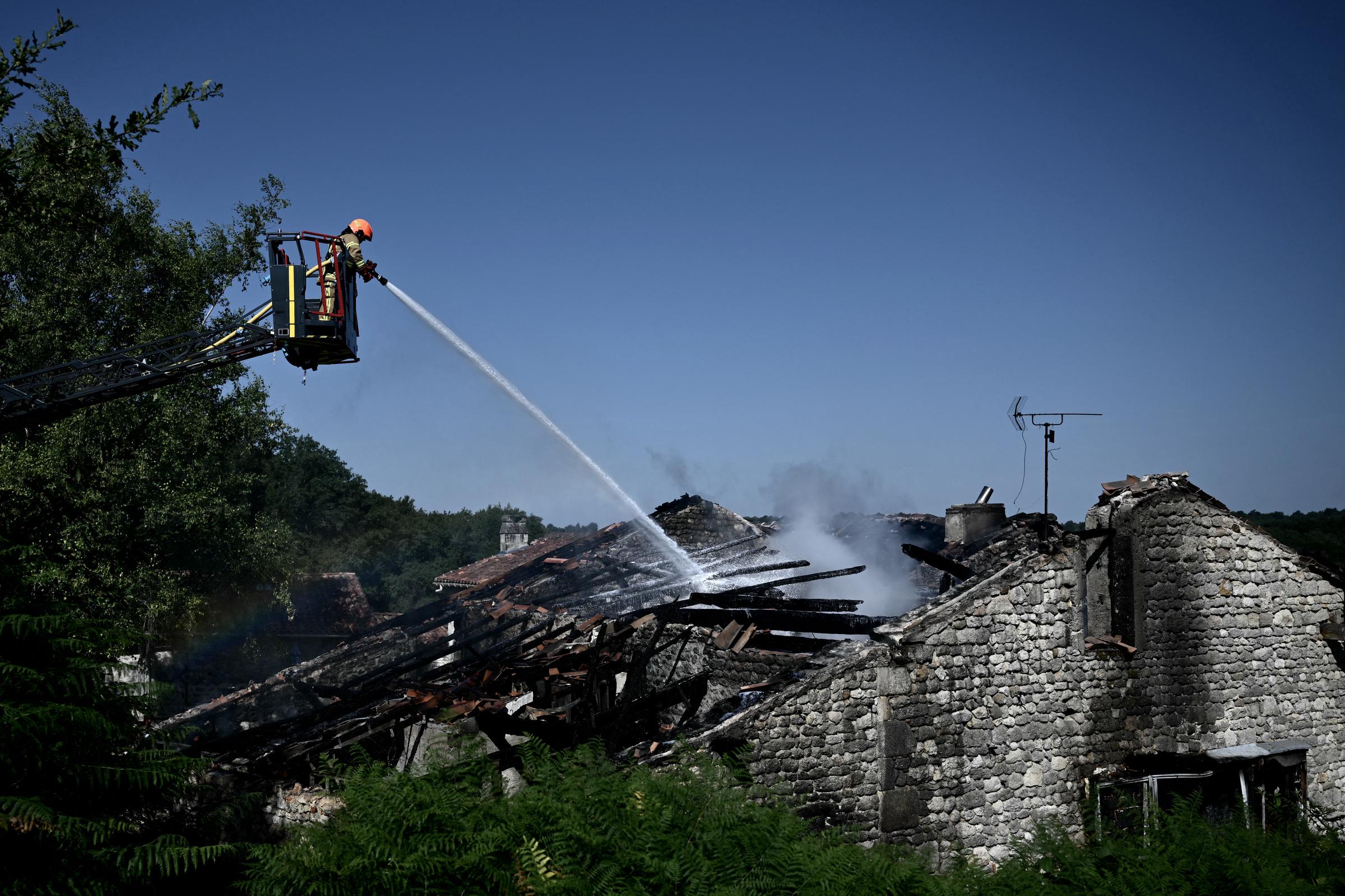 Un pompier intervient sur le site d'un gîte rural pour adultes handicapés où un incendie s'est déclaré, faisant un mort et quatre disparus, à Montmoreau, dans le sud-ouest de la France, le 28 juillet 2025 I Source : Getty Images