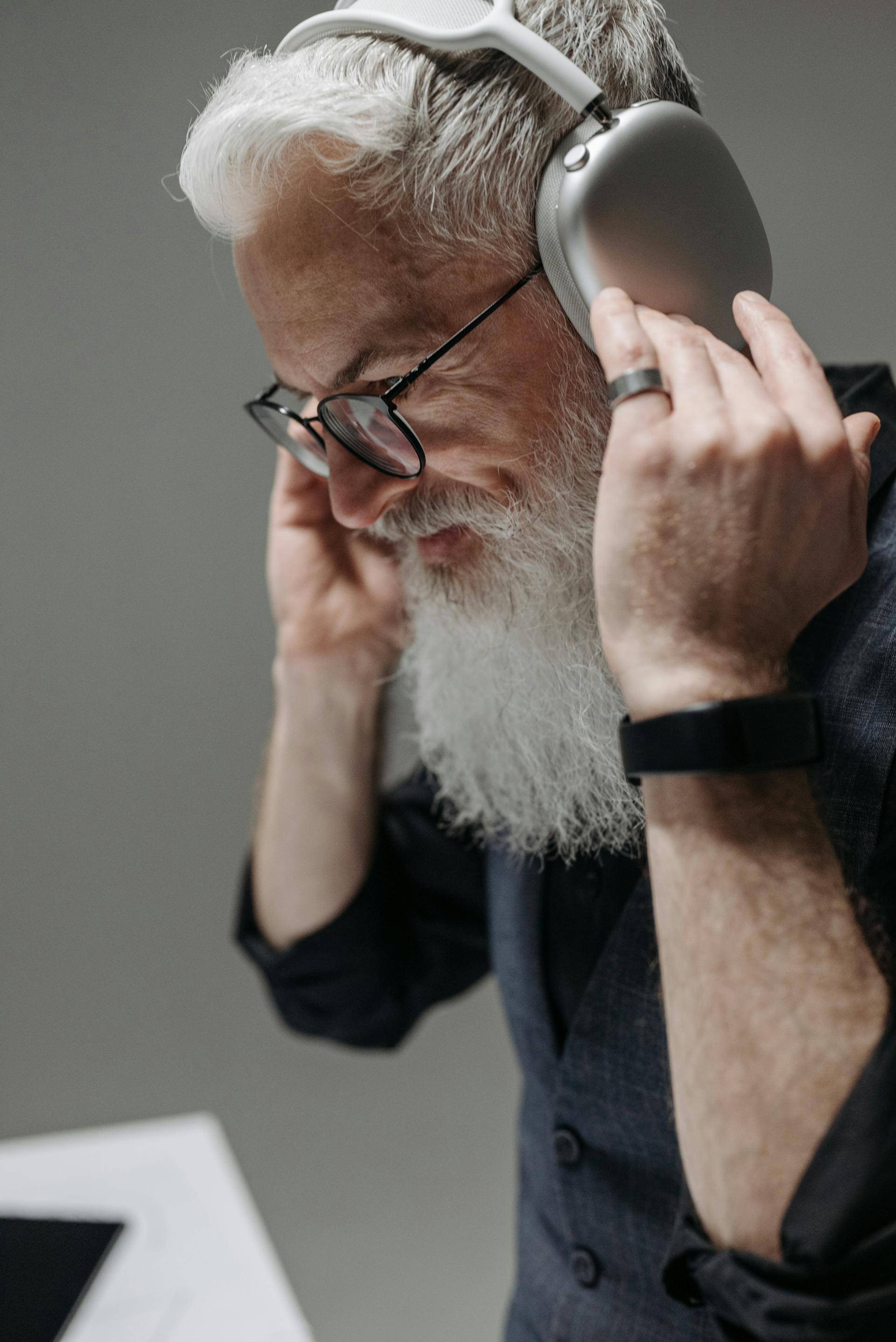 Un homme âgé souriant portant des écouteurs | Source : Pexels