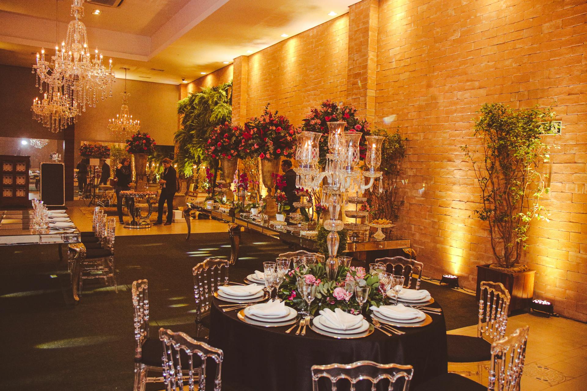 Une salle de banquet décorée de compositions florales et de lustres | Source : Pexels