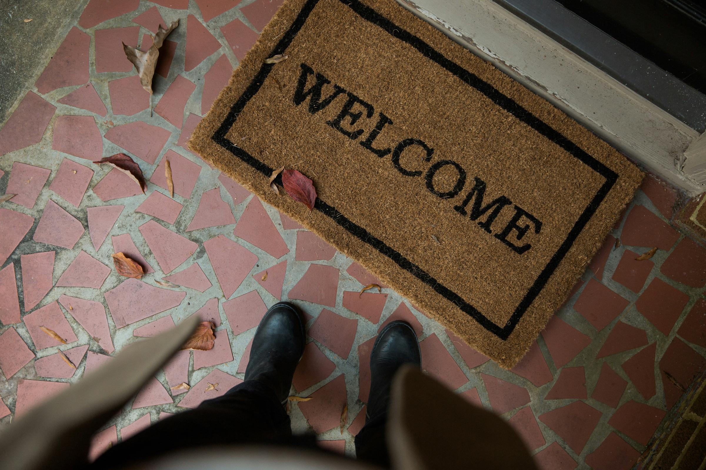 Une personne debout devant un tapis de bienvenue | Source : Unsplash