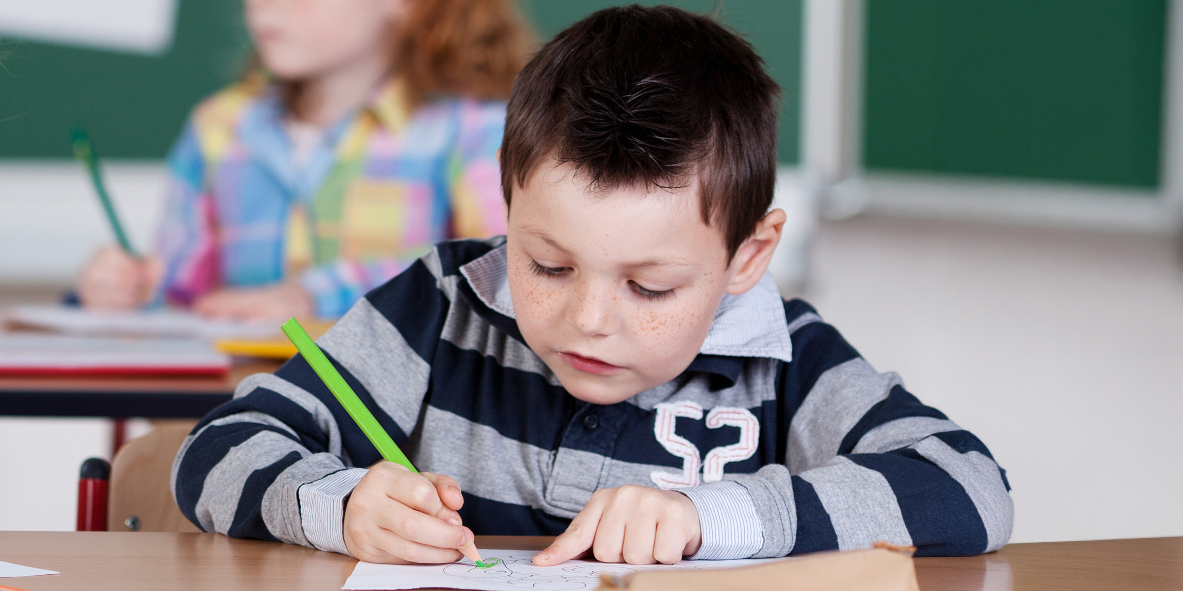 Un garçon qui fait un dessin en classe | Source : Shutterstock