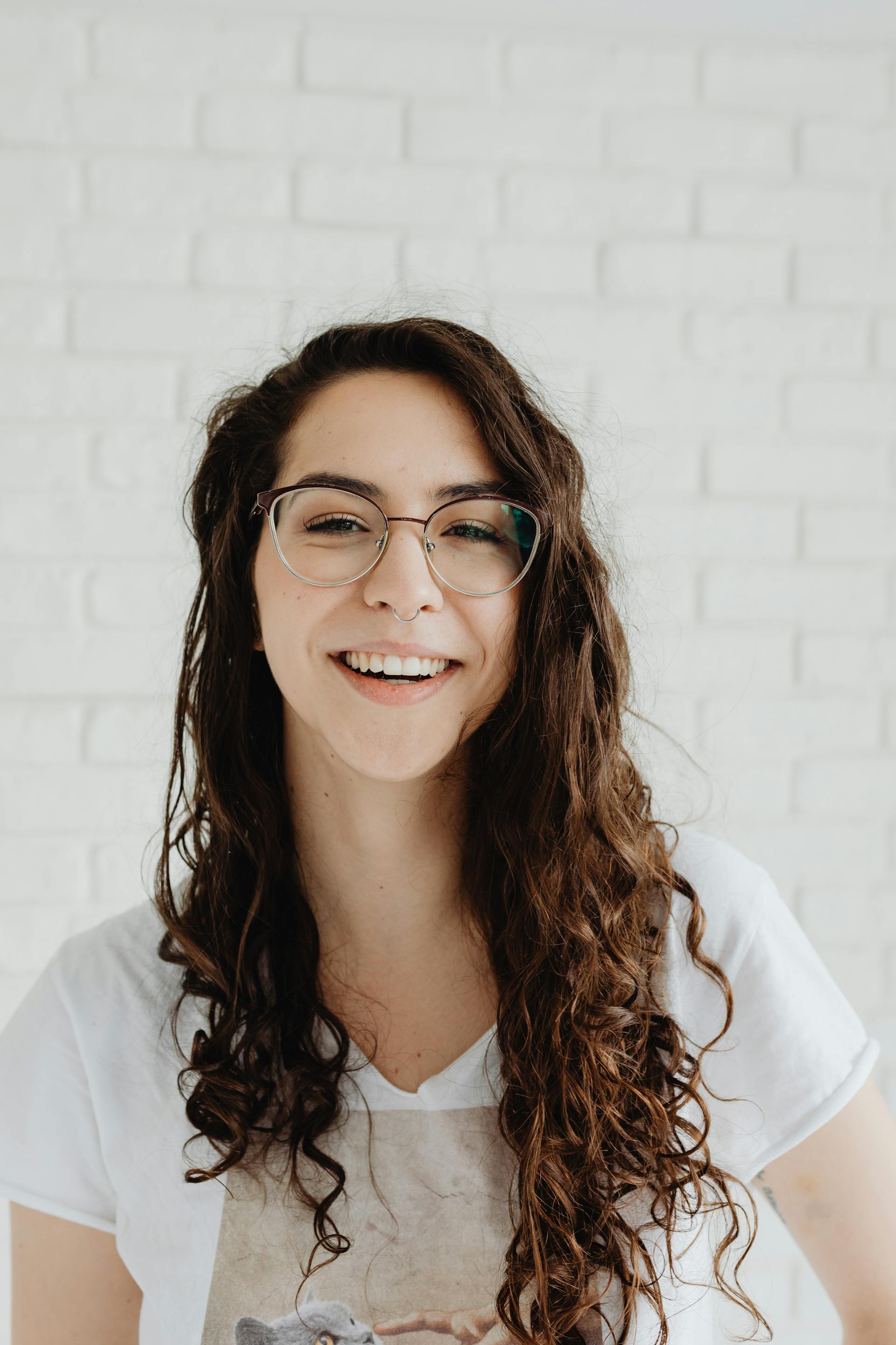 Une femme souriante portant des lunettes | Source : Pexels