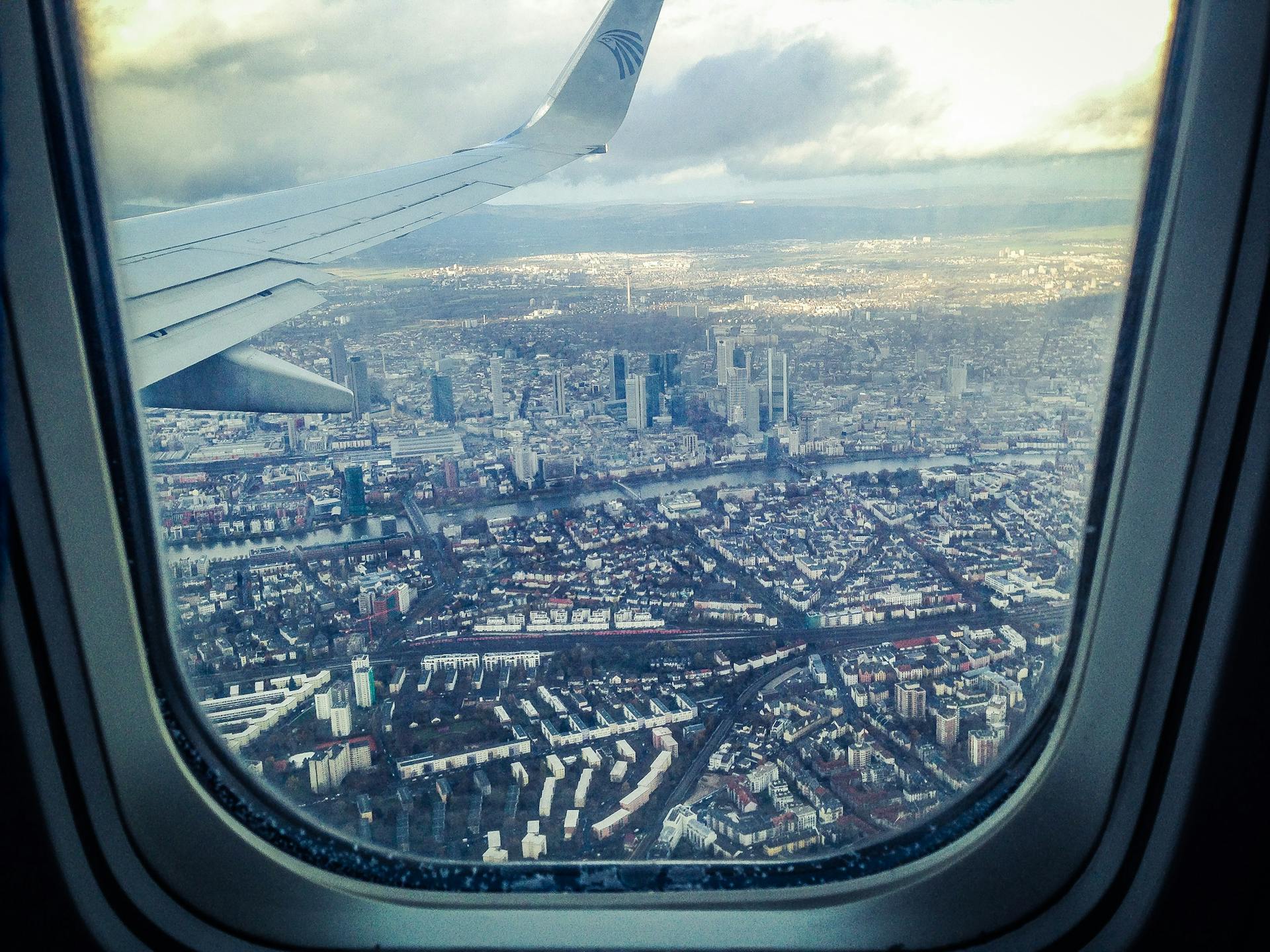 Une fenêtre d'avion montrant des bâtiments urbains | Source : Pexels