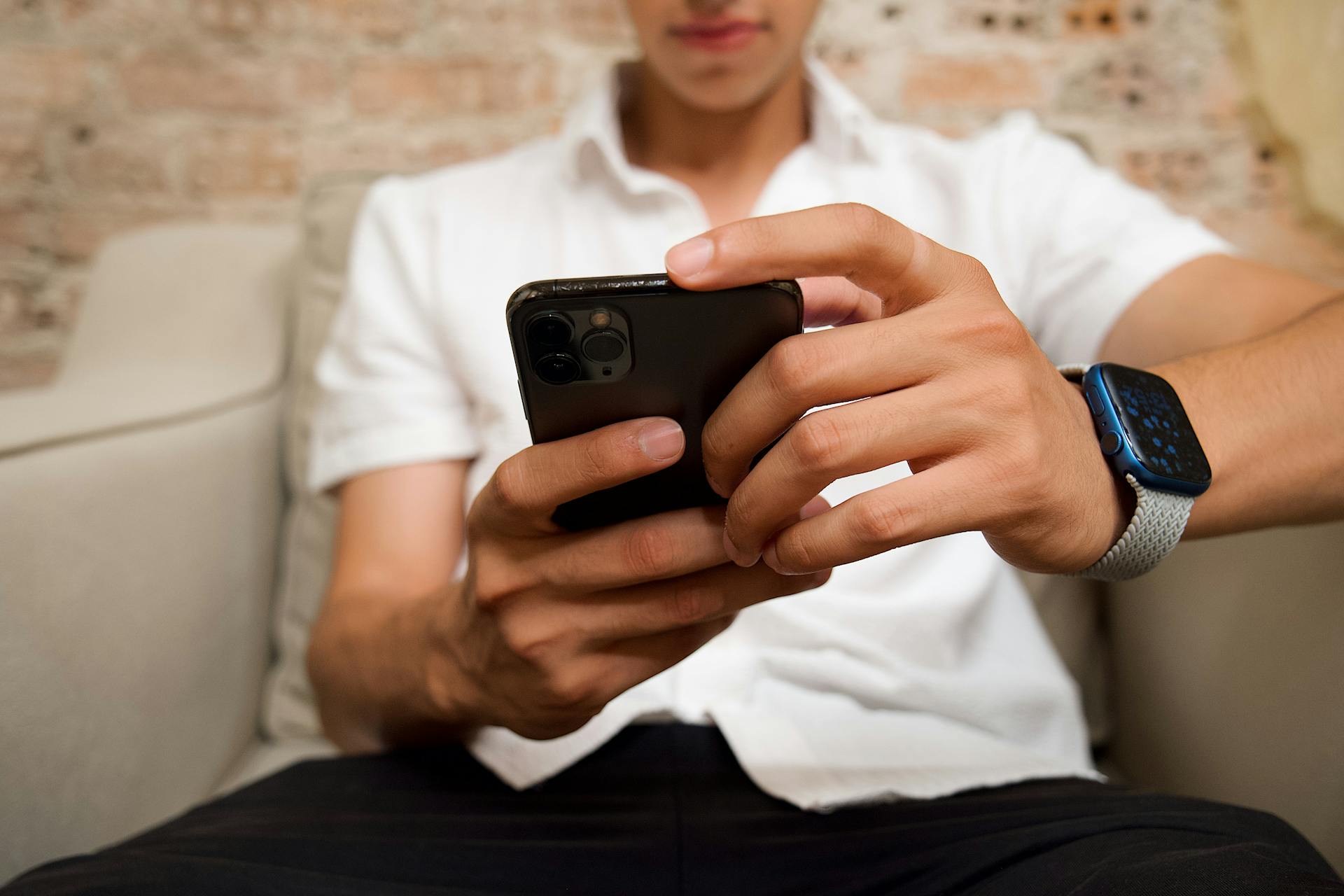 Un jeune homme vérifie son téléphone | Source : Pexels