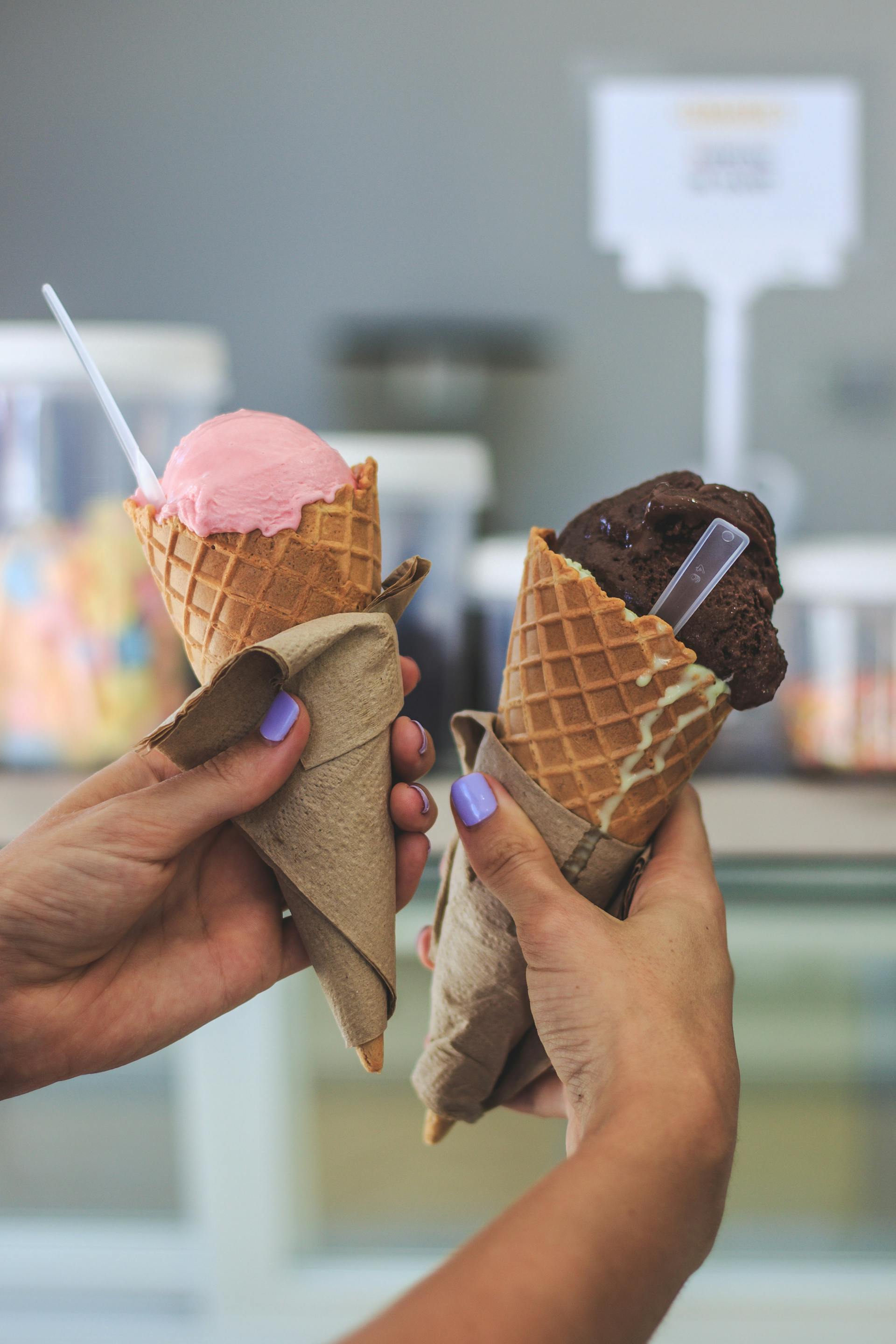 Gros plan d'une femme tenant deux cornets de crème glacée | Source : Pexels