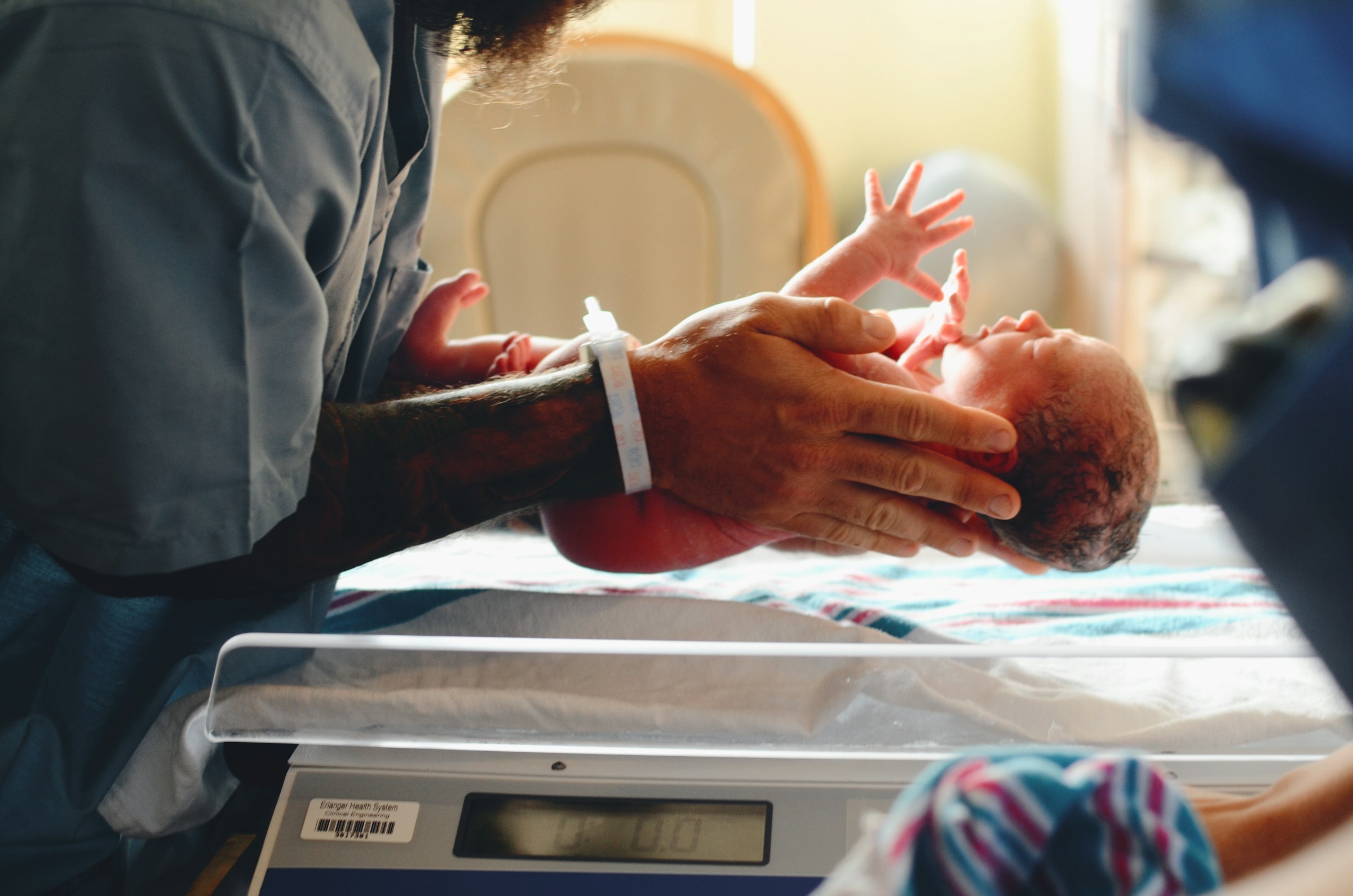 Un médecin mettant un nouveau-né sur la balance | Source : Unsplash