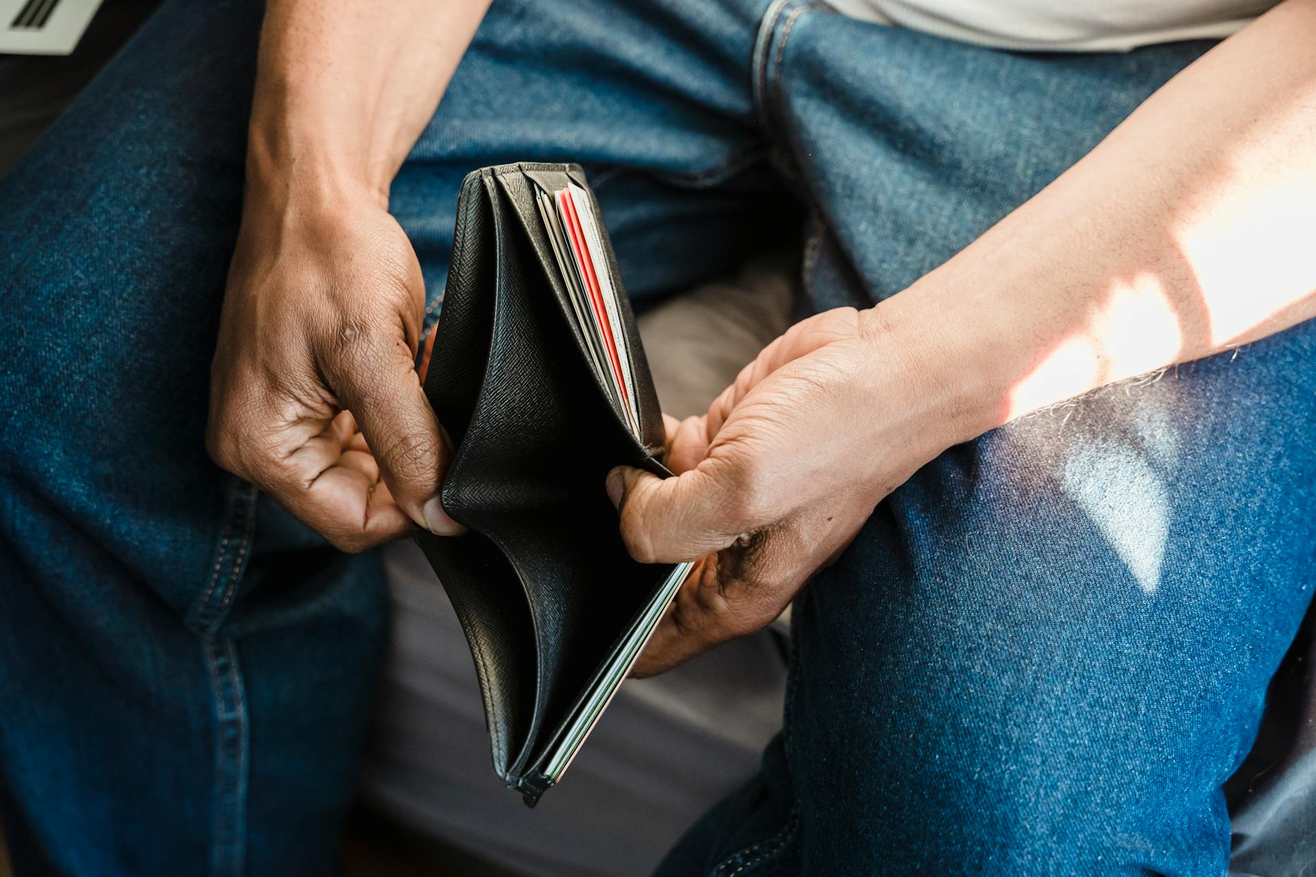 Un homme tenant son portefeuille | Source : Pexels