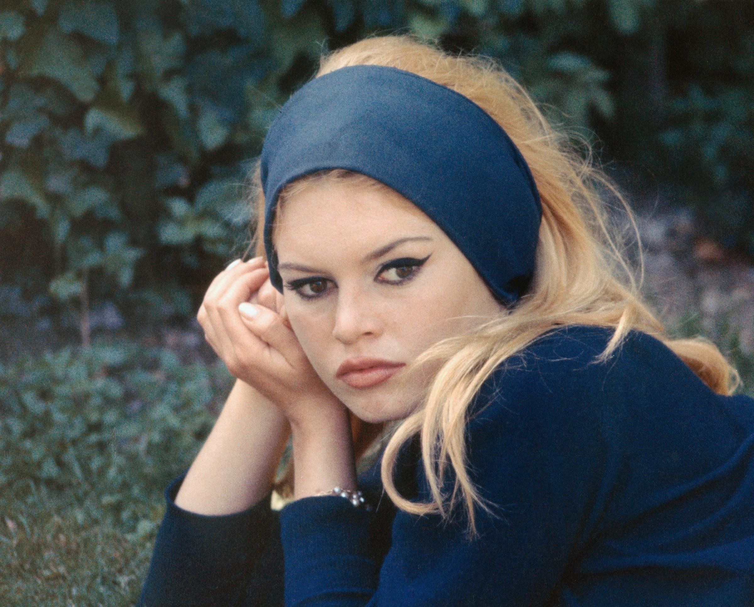 Brigitte Bardot est photographiée sur un plateau de tournage, la tête posée sur ses mains, le regard tourné vers l'appareil photo | Source : Getty Images