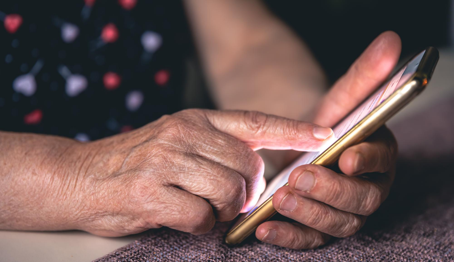 Gros plan d'une femme âgée tenant un téléphone | Source : Freepik