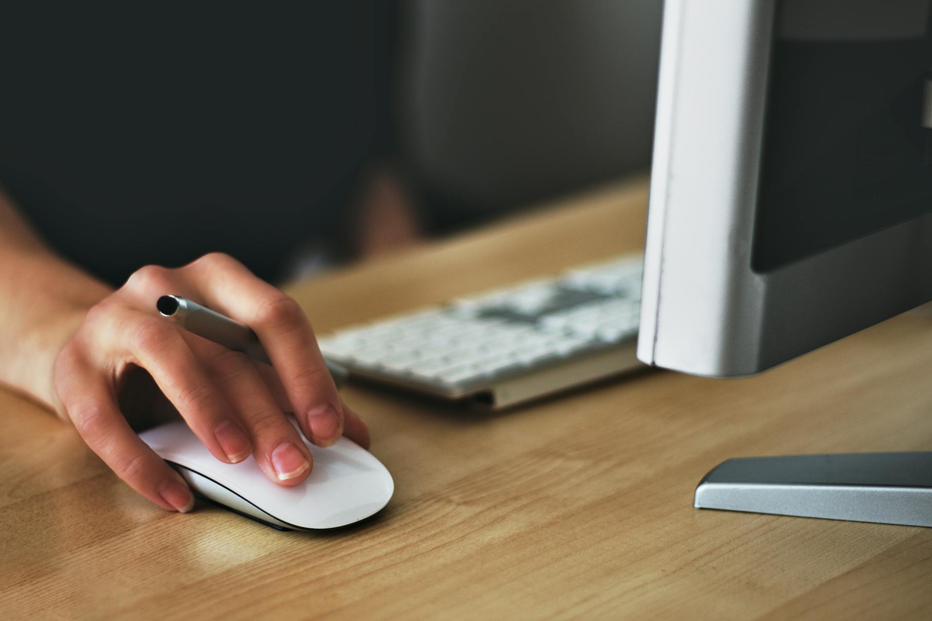 Une personne tenant un stylo et une souris | Source : Pexels