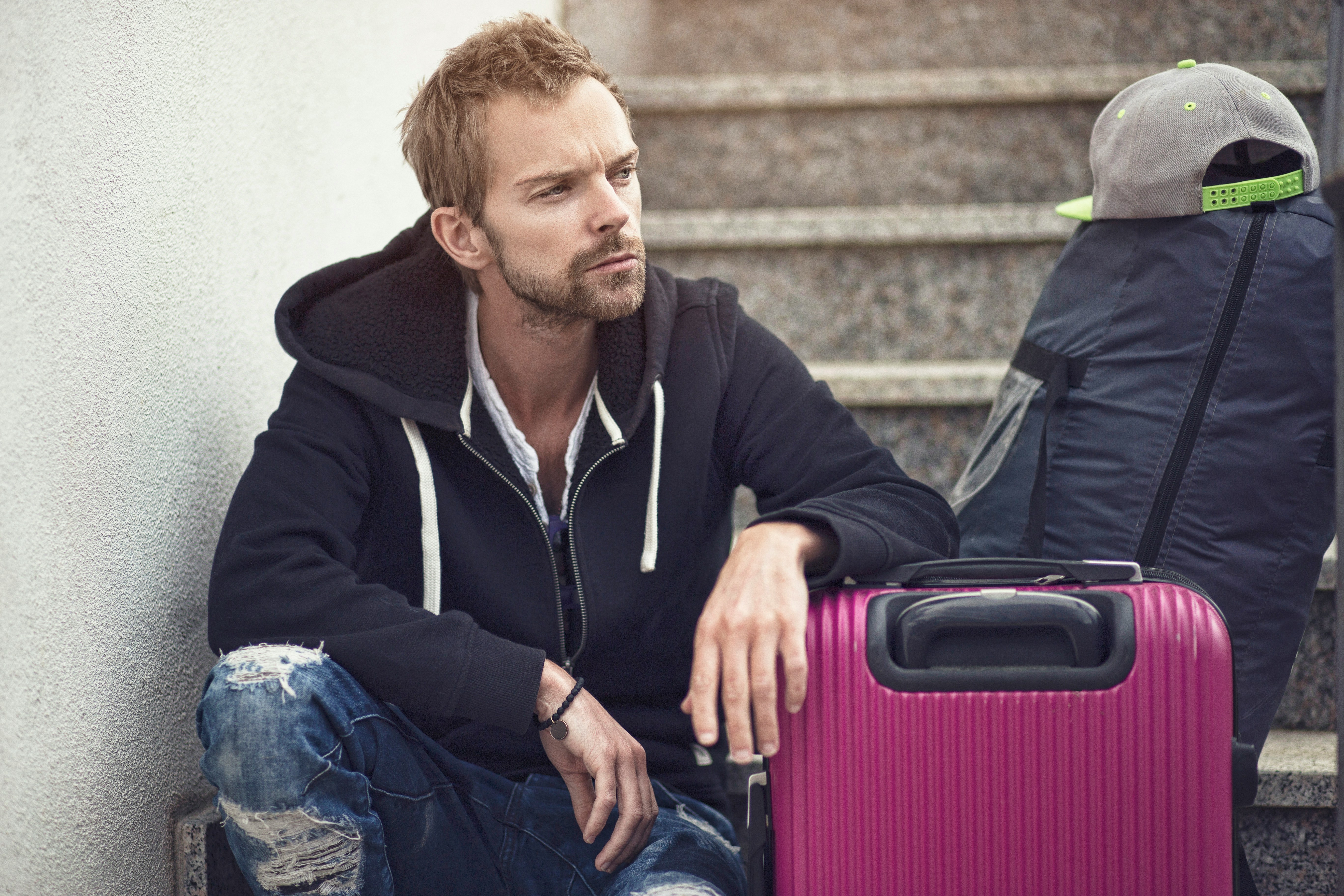 Un homme assis avec des bagages | Source : Unsplash