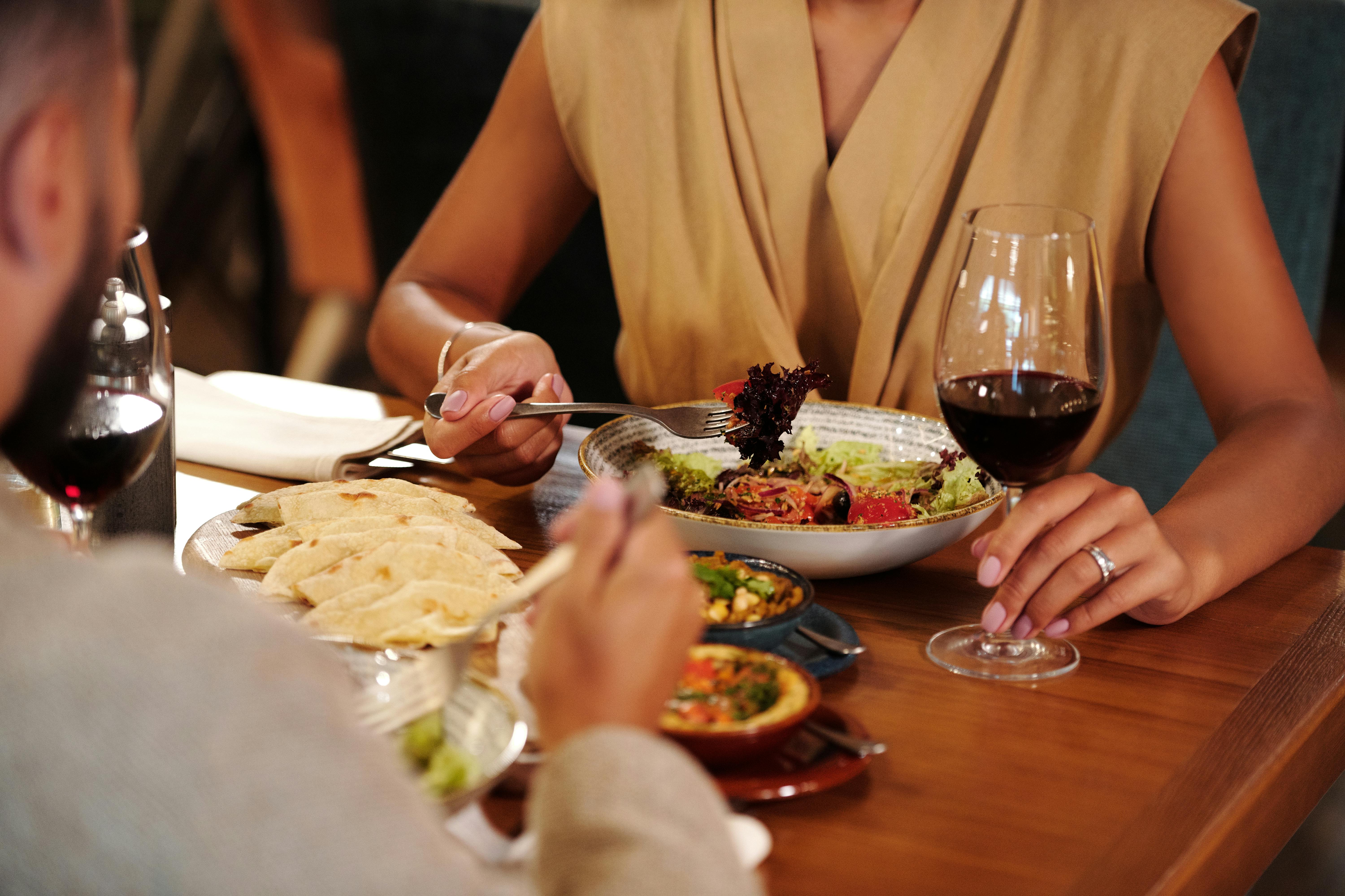 Femme, portant une bague de fiançailles, lors d'un dîner avec son fiancé | Source : Pexels