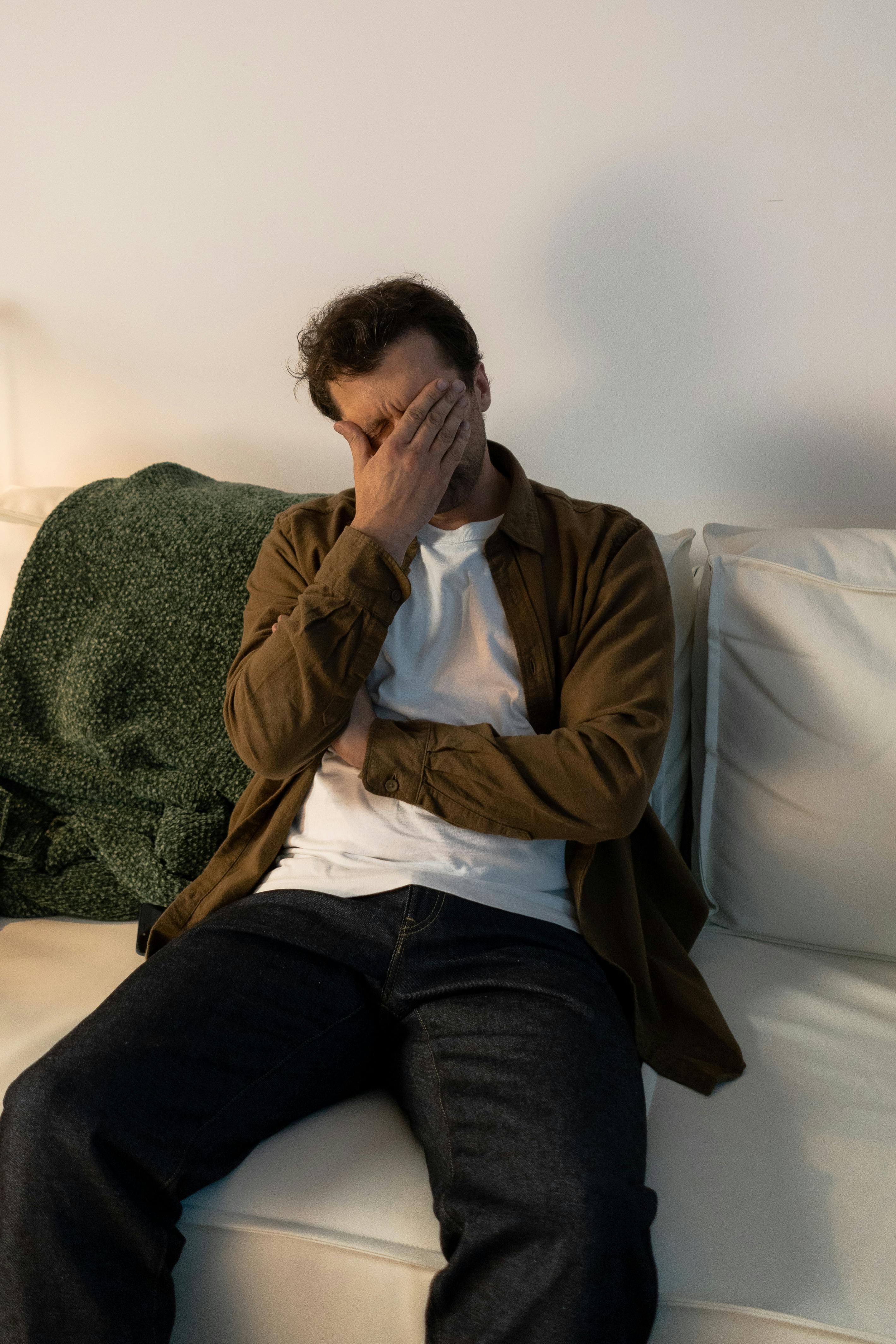 Un homme bouleversé se couvrant le visage | Source : Pexels