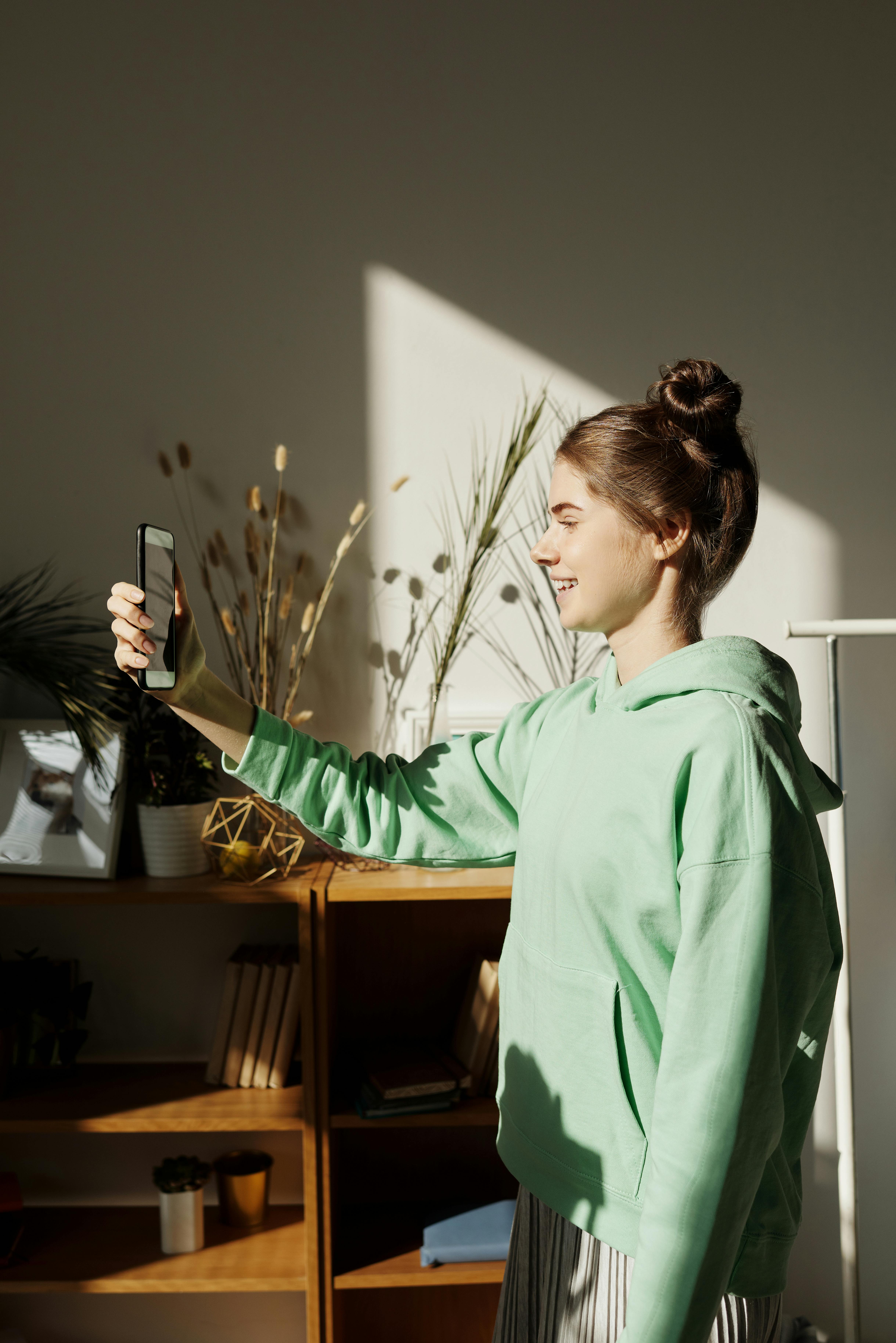 Une fille qui rit en enregistrant avec son téléphone | Source : Pexels
