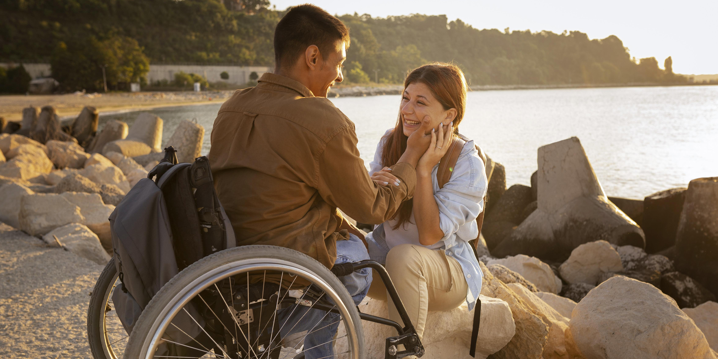 Une femme heureuse assise à côté de son mari en fauteuil roulant | Source : Freepik