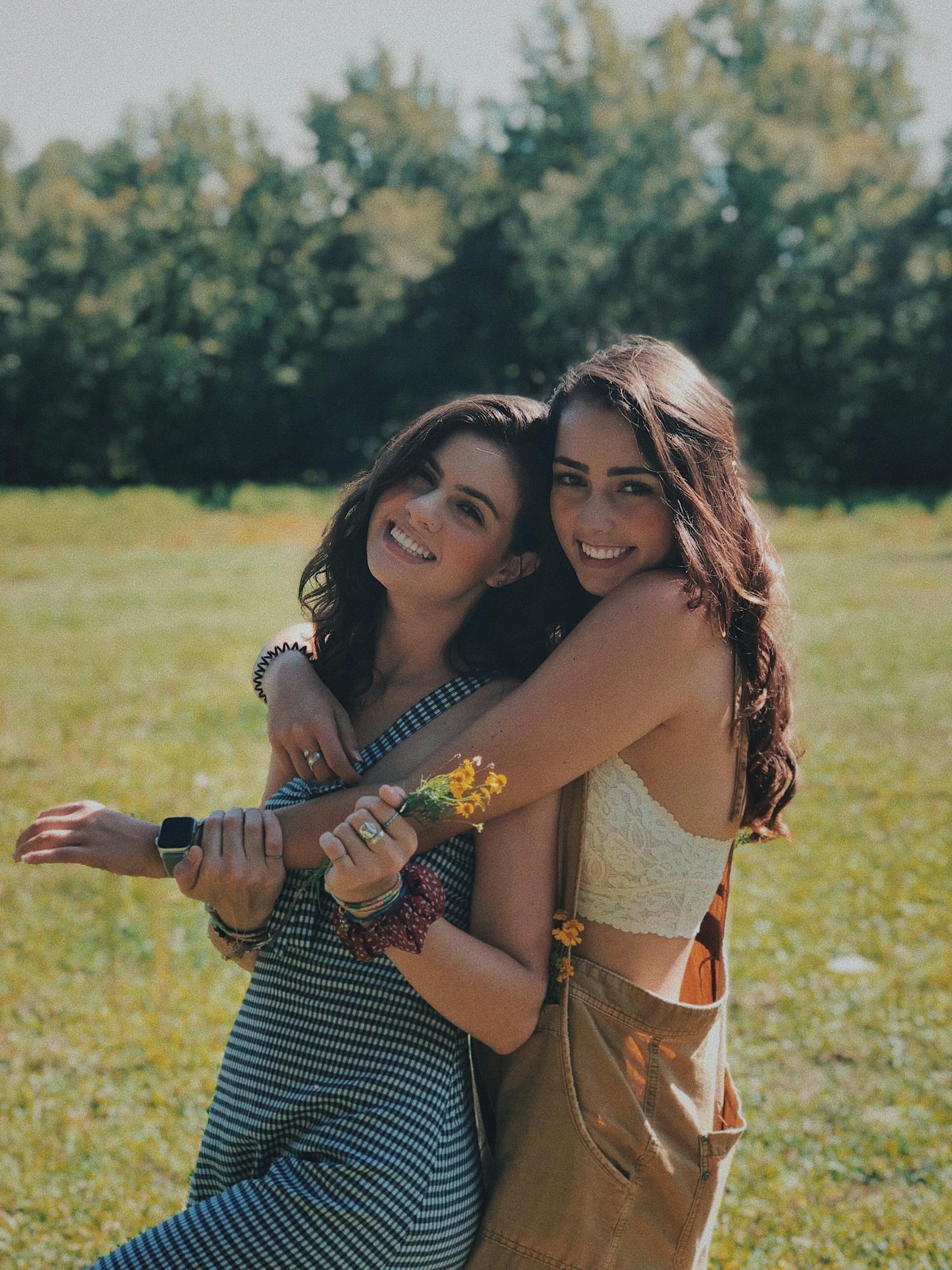 Jeunes femmes souriantes se prenant dans les bras | Source : Pexels