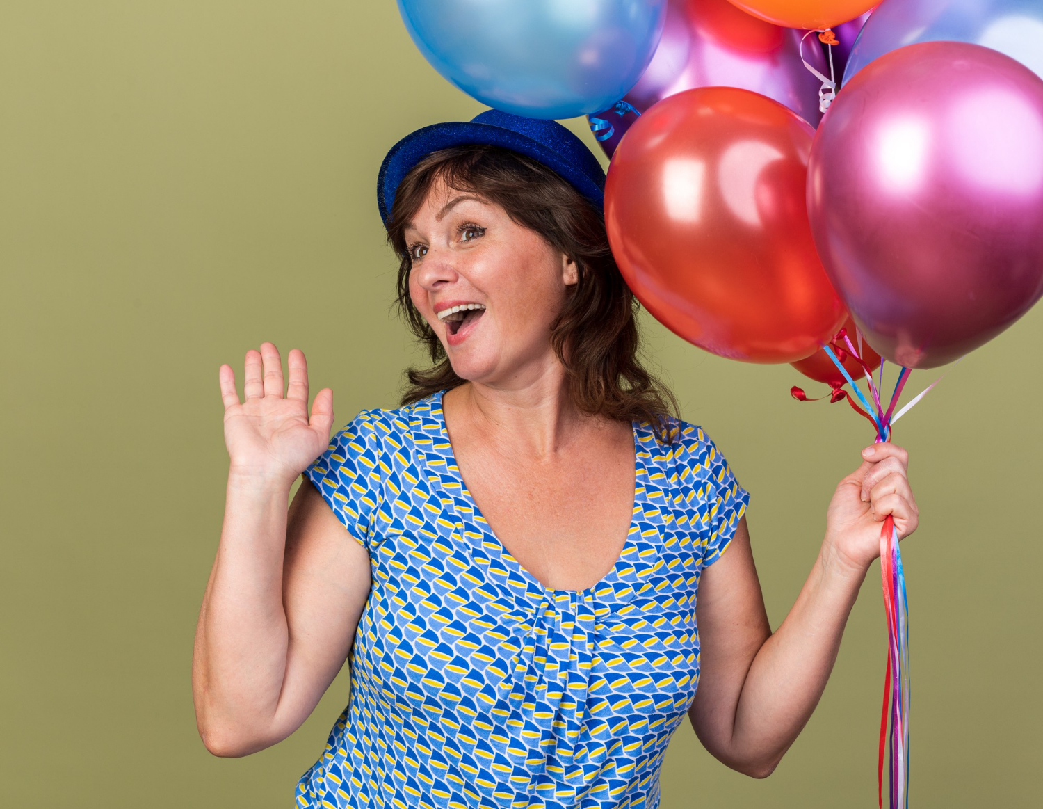 Une femme âgée ravie tenant des ballons | Source : Freepik