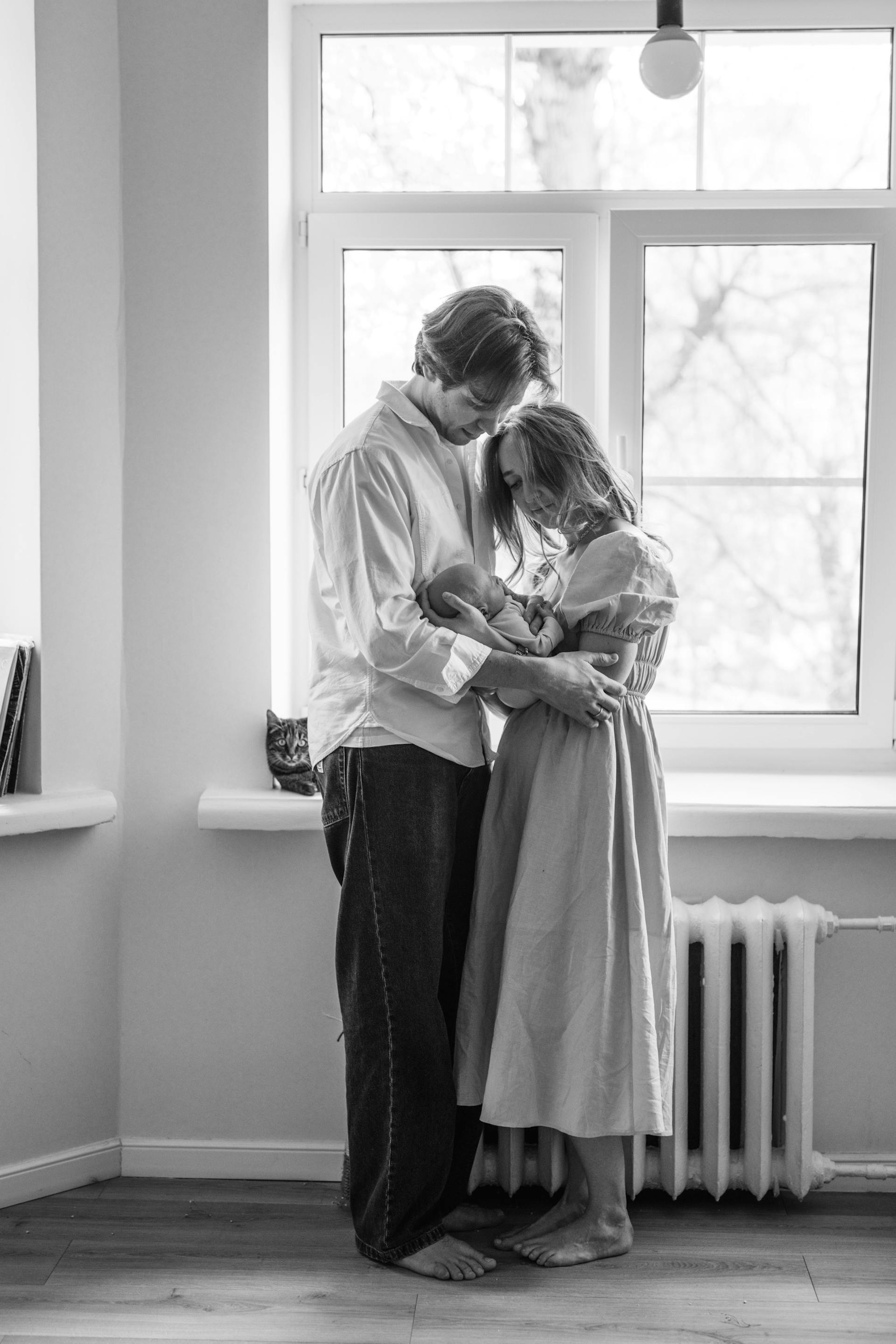 Photo en niveaux de gris d'un couple tenant un nouveau-né | Source : Pexels