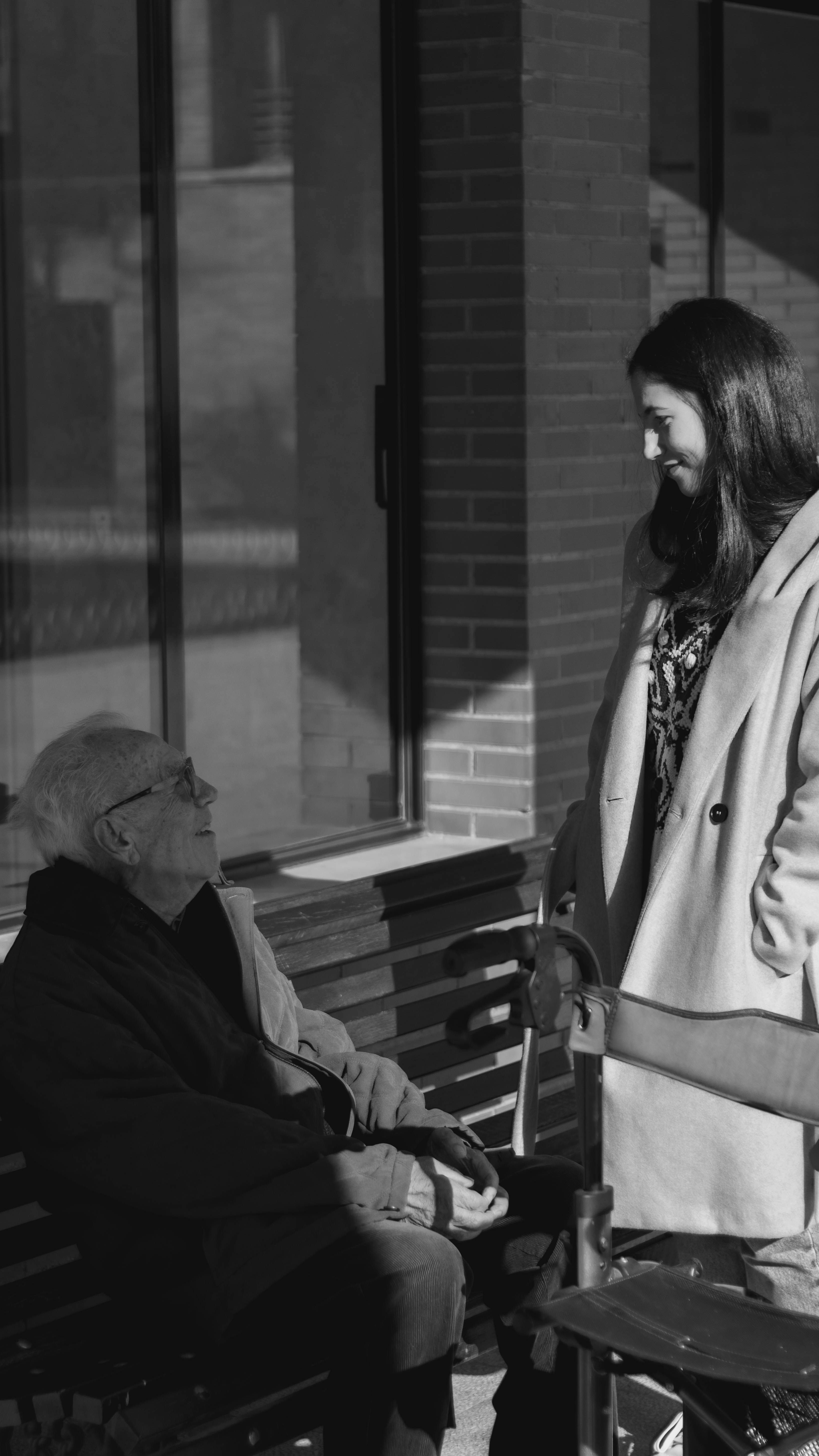 Homme âgé assis sur un banc parlant à une femme | Source : Unsplash