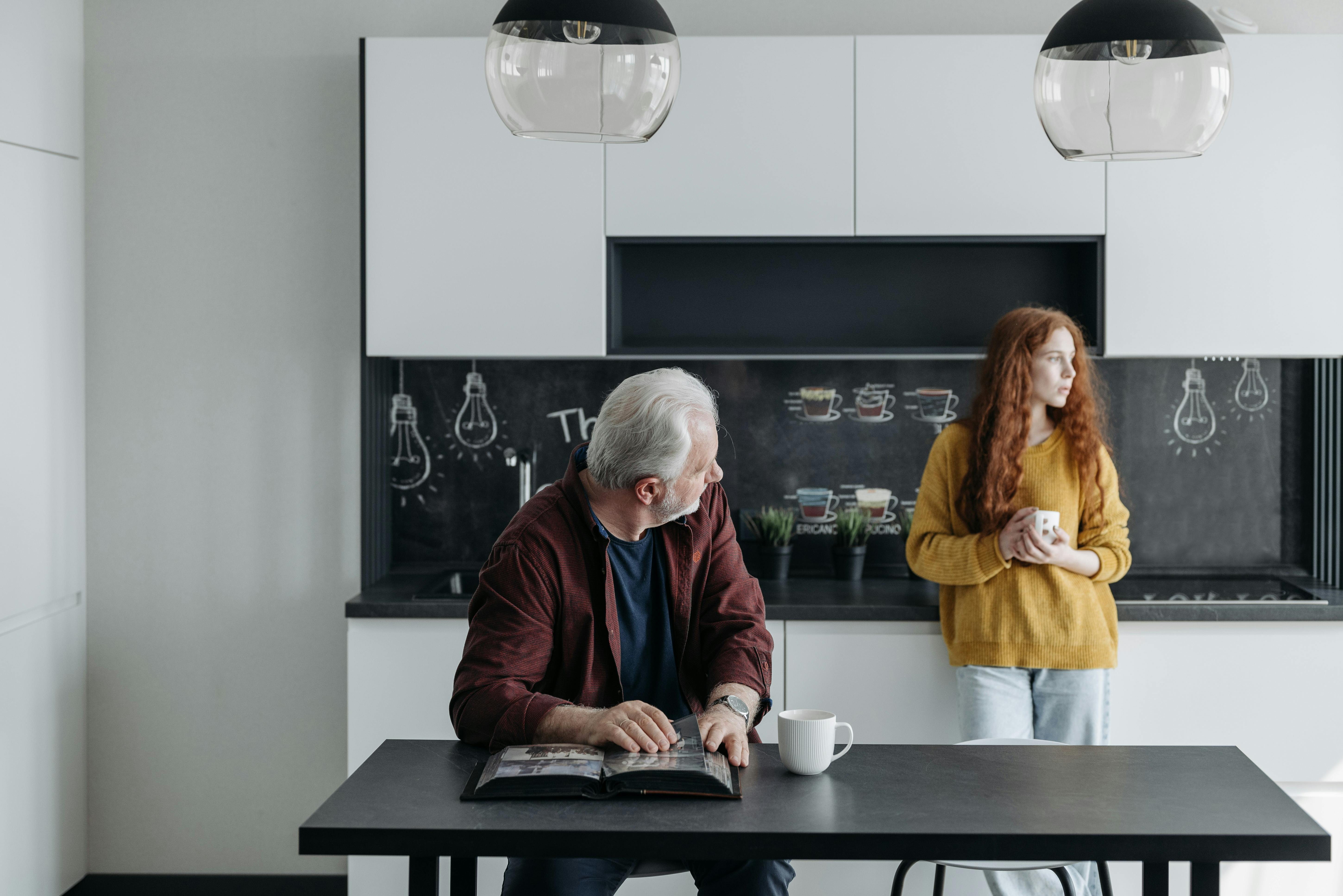 Un homme assis à la table tout en regardant une femme | Source : Pexels