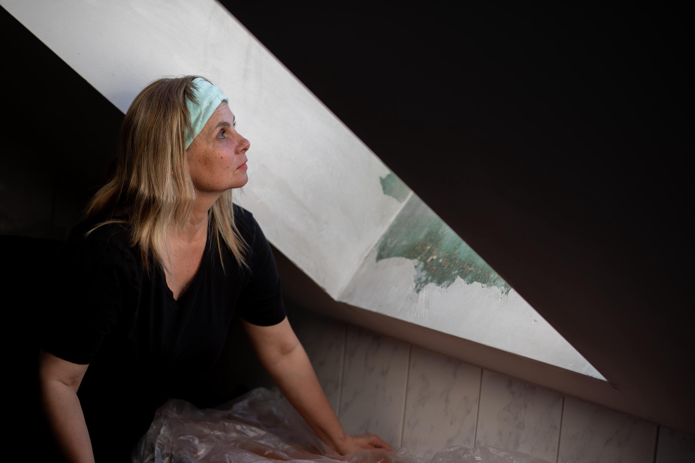 Femme regardant la fenêtre du grenier | Source : Shutterstock