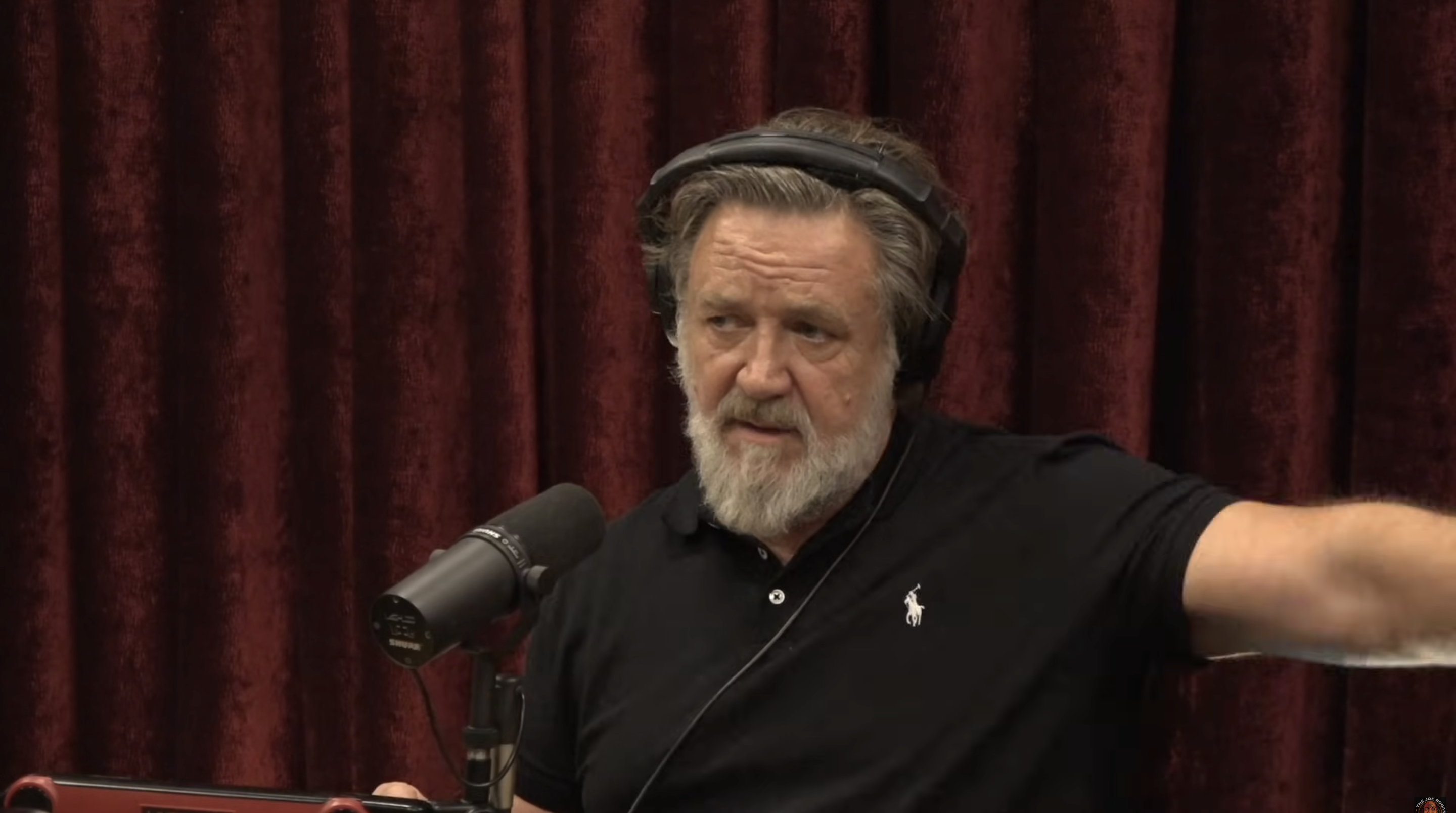 Russell Crowe semble concentré et spontané dans une vidéo datée du 5 novembre 2025, où il s'exprime dans l'émission « The Joe Rogan Experience ». Vêtu d'un polo noir et équipé d'un casque audio, l'acteur parle ouvertement de sa perte de poids de 25 kg et des pratiques santé qui l'ont aidé à se transformer. | Source : YouTube/PowerfulJRE