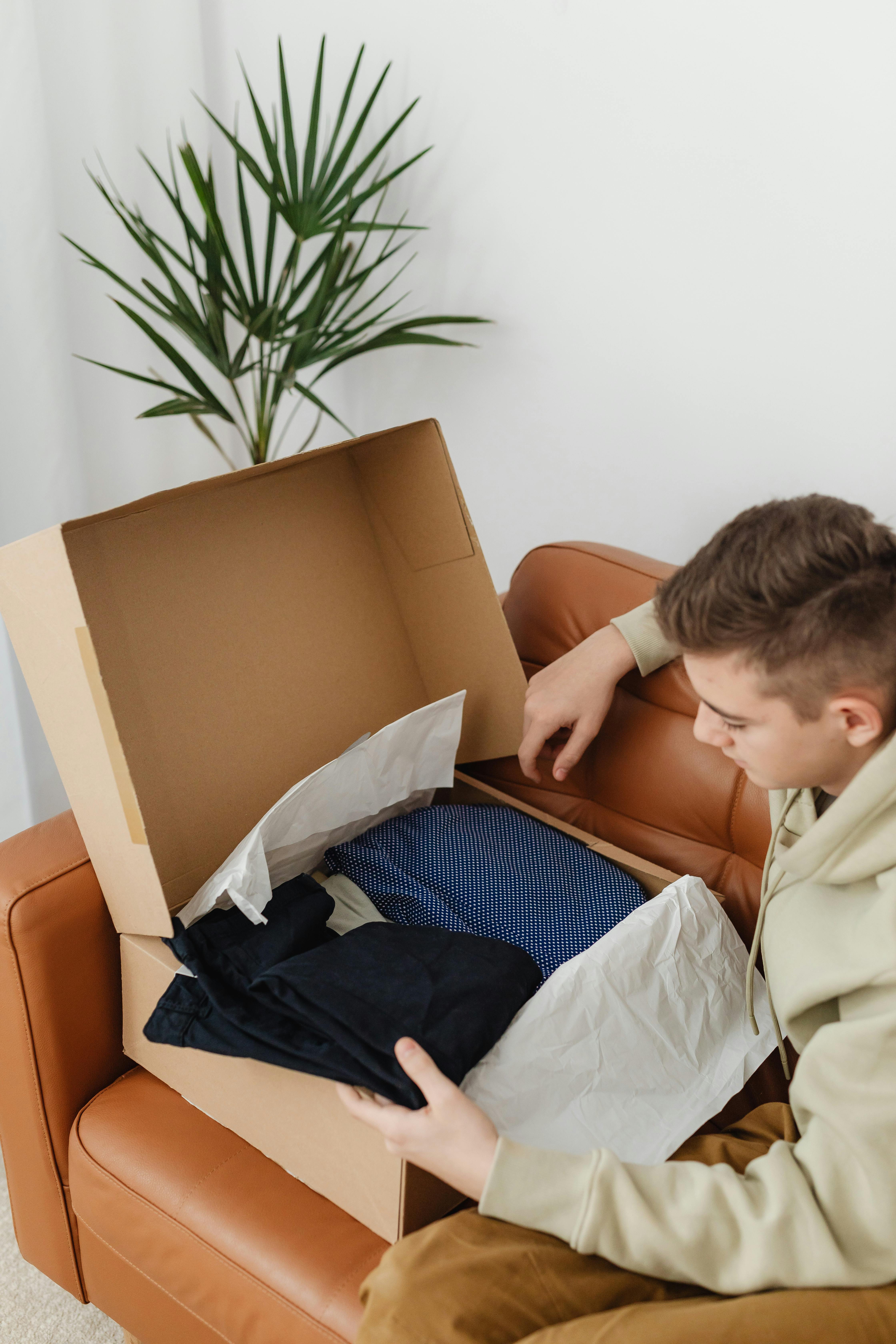 Un garçon qui regarde ses nouveaux vêtements | Source : Pexels