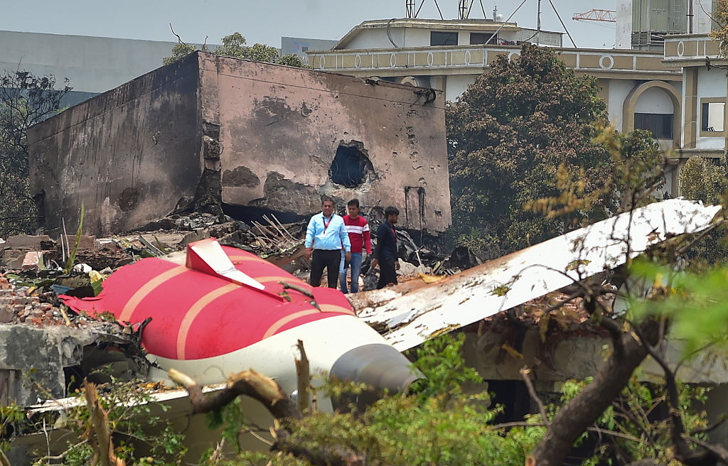 Des enquêteurs se tiennent sur les lieux du crash du Boeing 787 d'Air India, hier, le 13 juin 2025, à Ahmedabad, en Inde. | Source : Getty Images