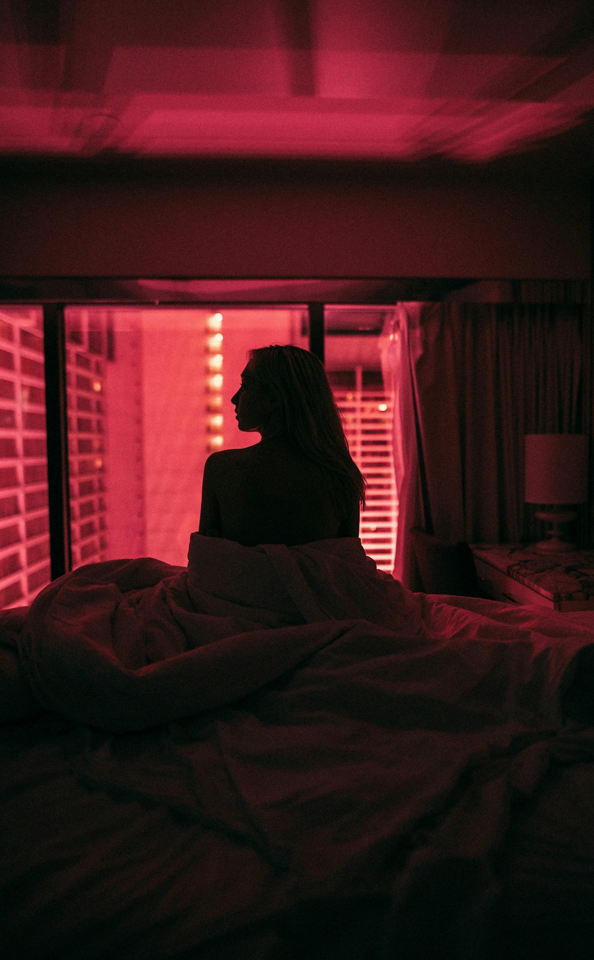 Une femme assise dans son lit la nuit | Source : Pexels