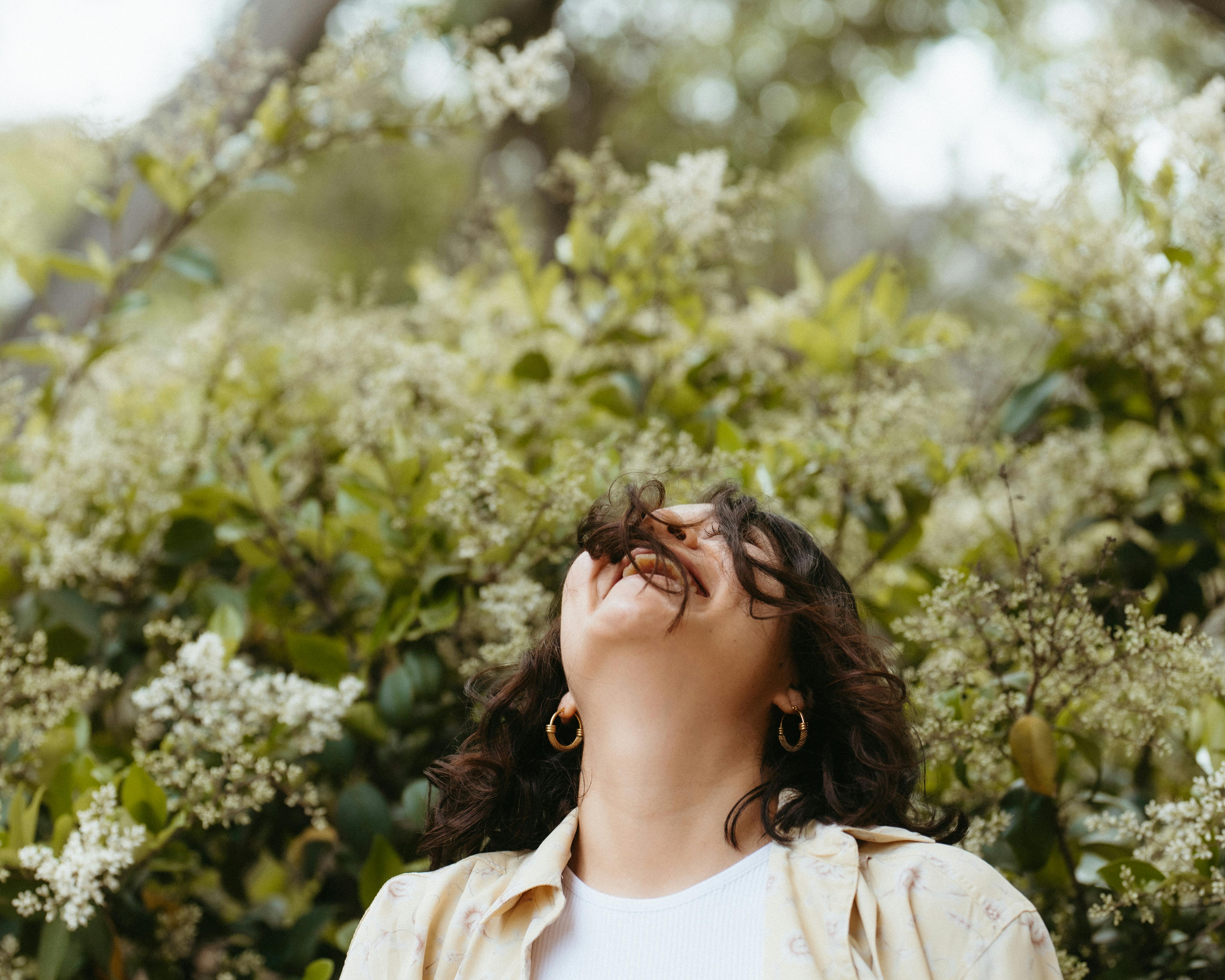 Une femme qui penche la tête en arrière en riant | Source : Pexels