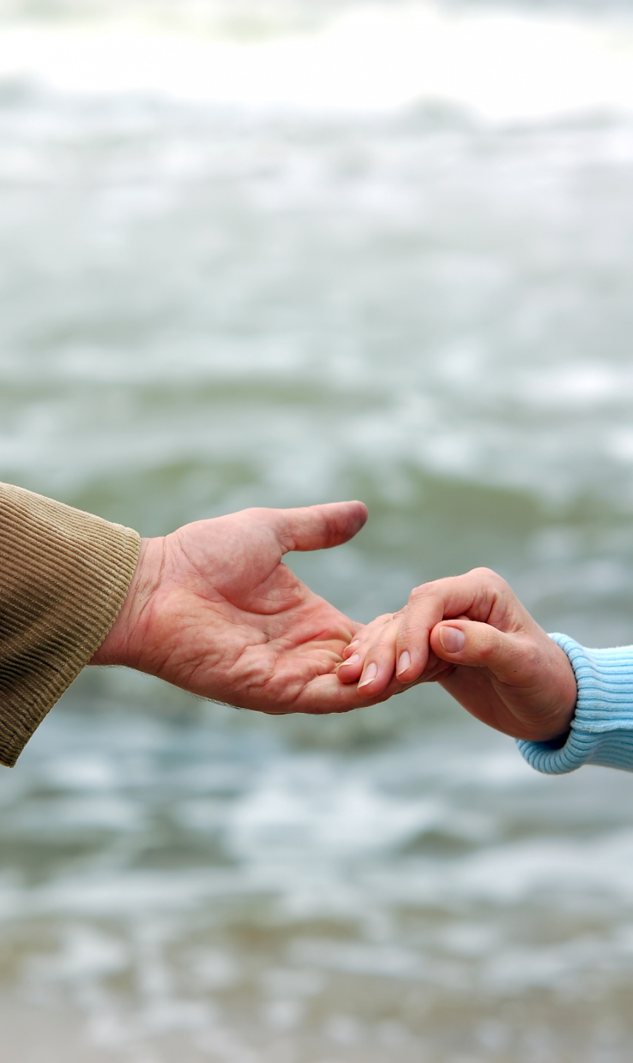 Un jeune et une personne plus âgée se tenant par la main | Source : Freepik