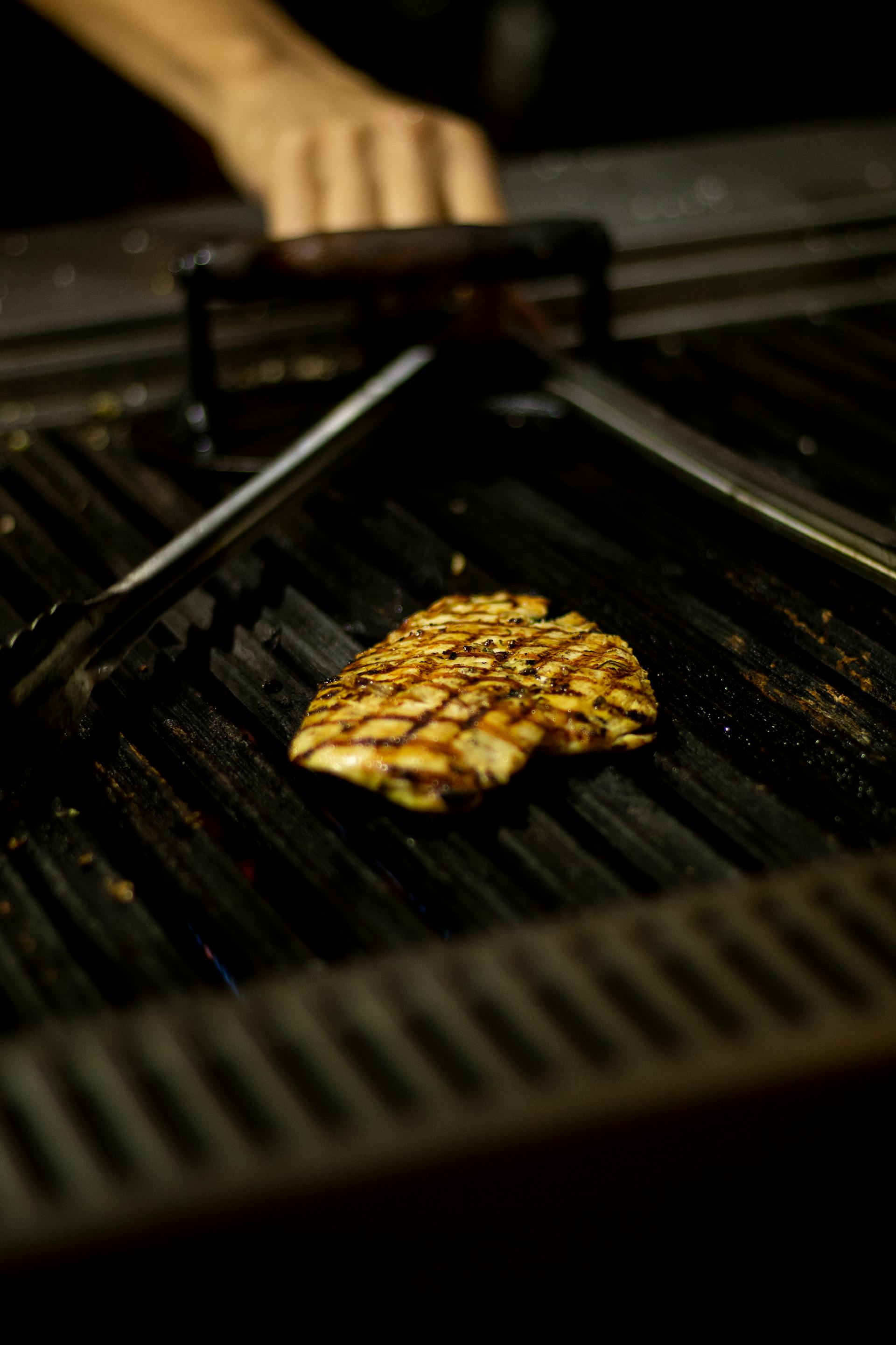 Un blanc de poulet en train de cuire sur un grill | Source : Pexels