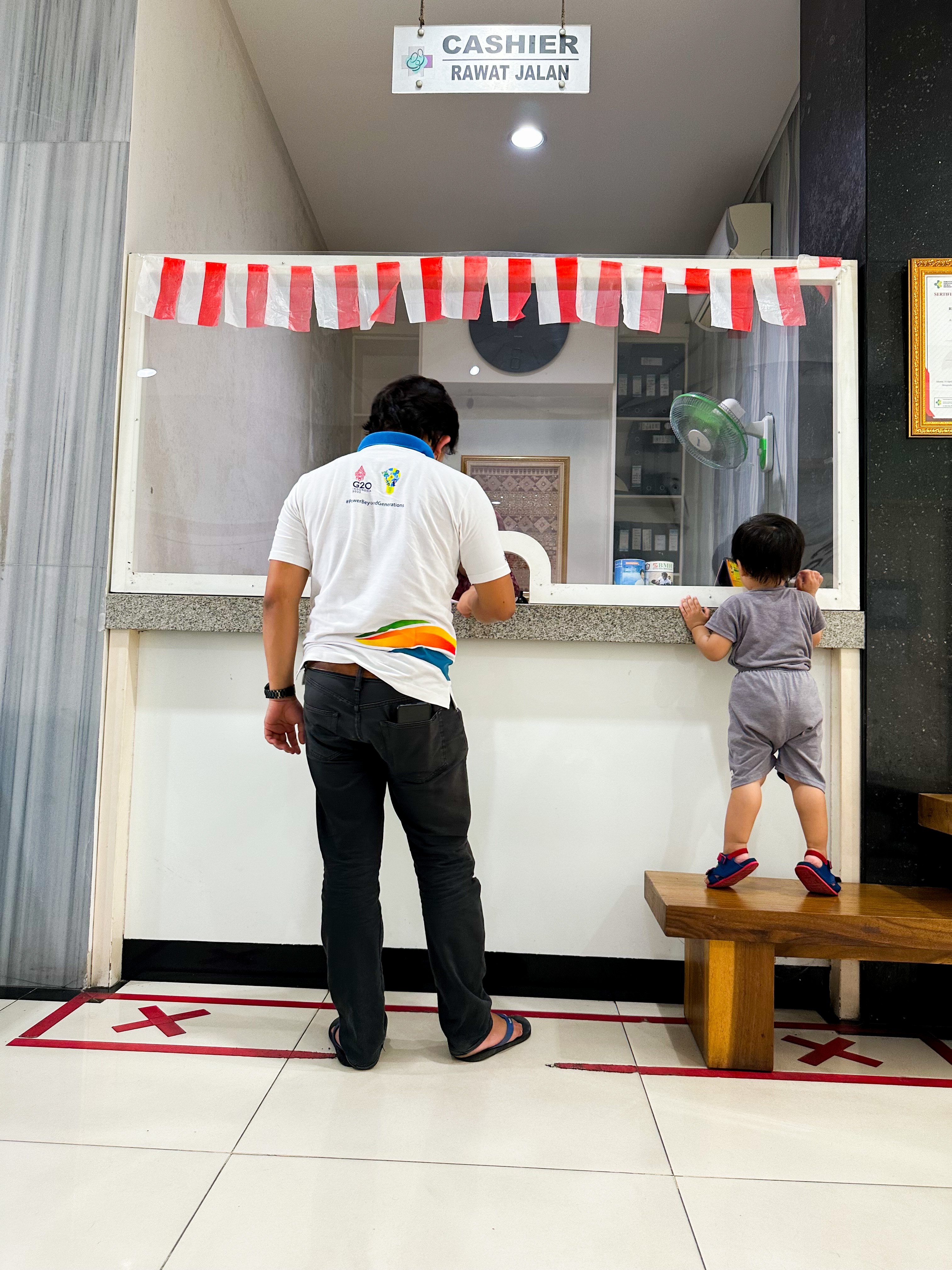 Un homme debout devant la caisse avec son enfant | Source : Shutterstock