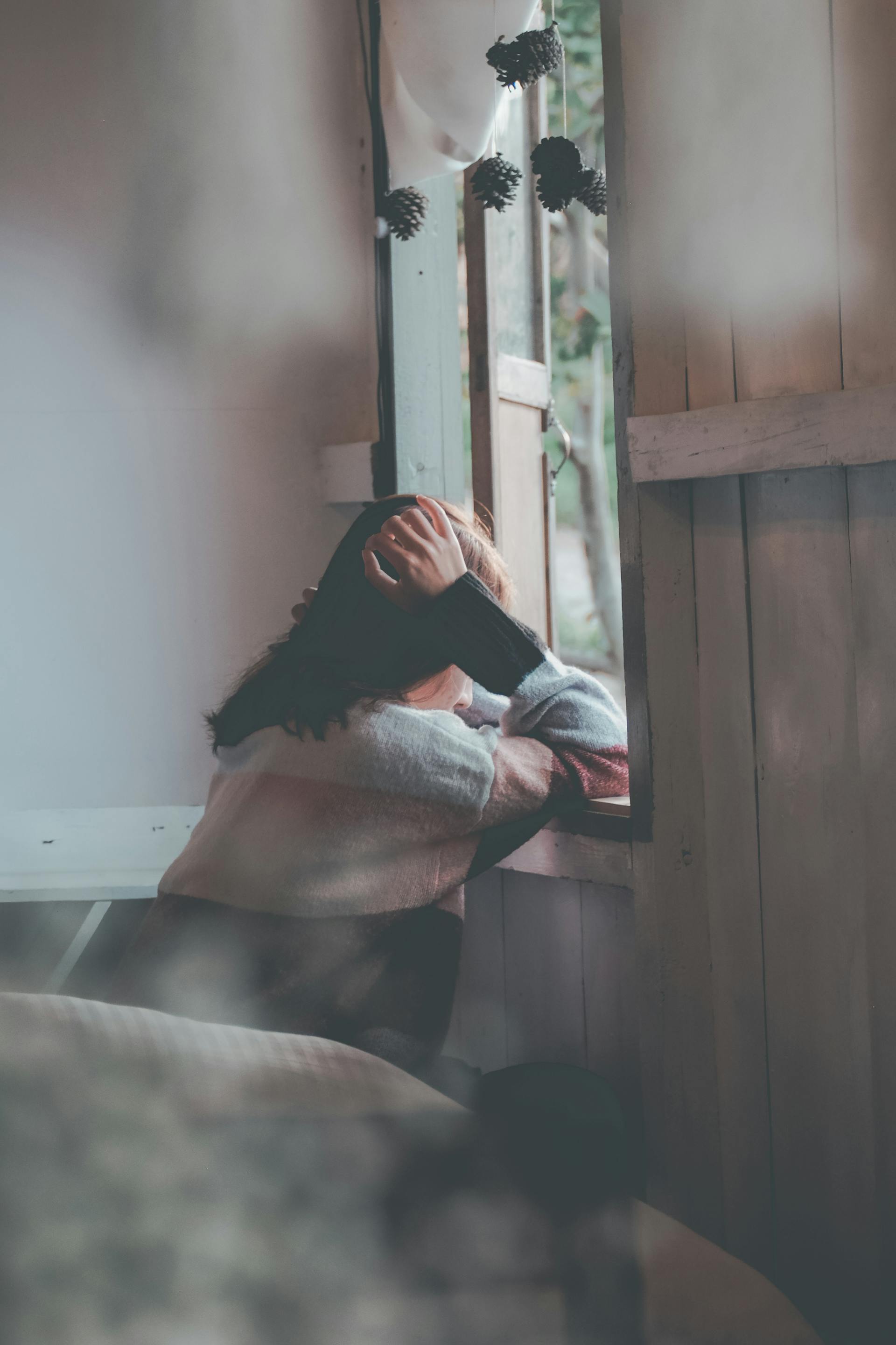 Une femme appuyée sur une fenêtre en bois | Source : Pexels