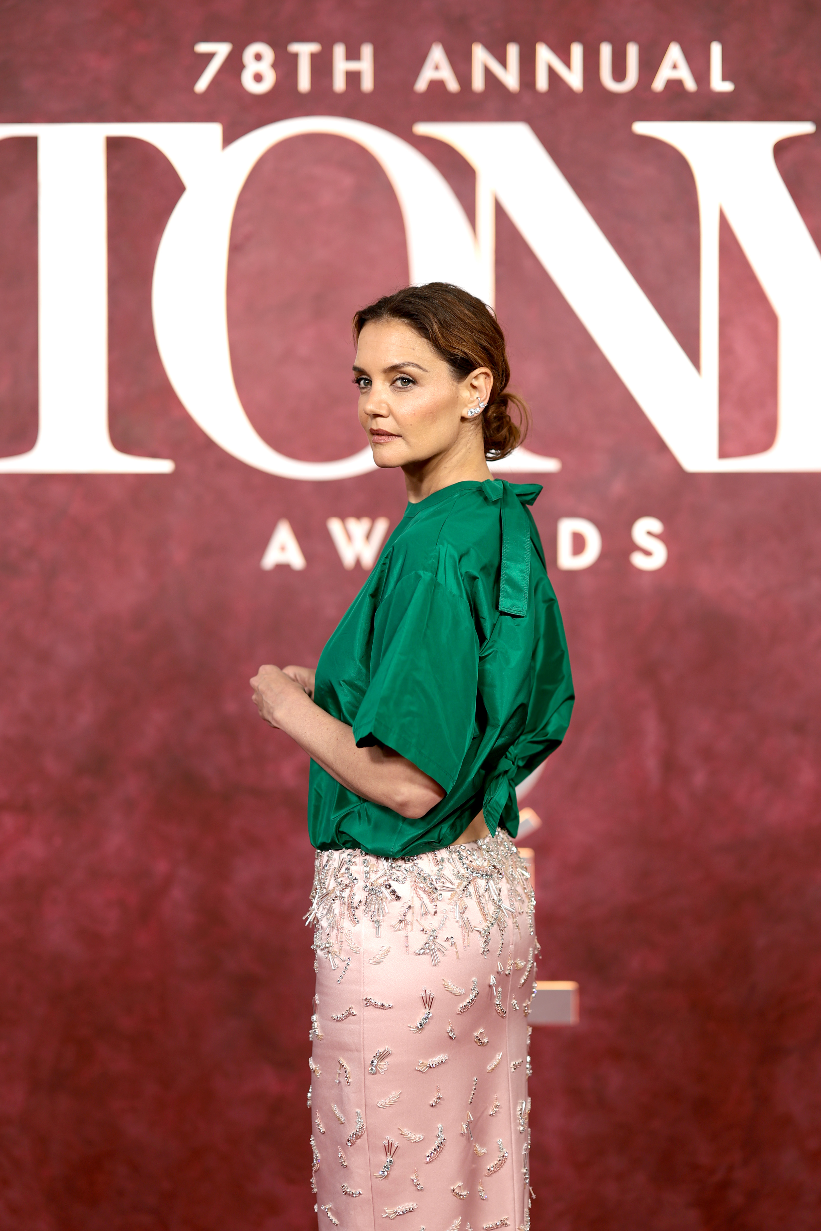 Sur la toile de fond emblématique des Tony Awards, Katie Holmes fait une pause de profil, son look bicolore audacieux - vert satiné sur le dessus, rose blush et perles argentées en dessous - ayant fermement capté l'attention des observateurs de la mode et des photographes.