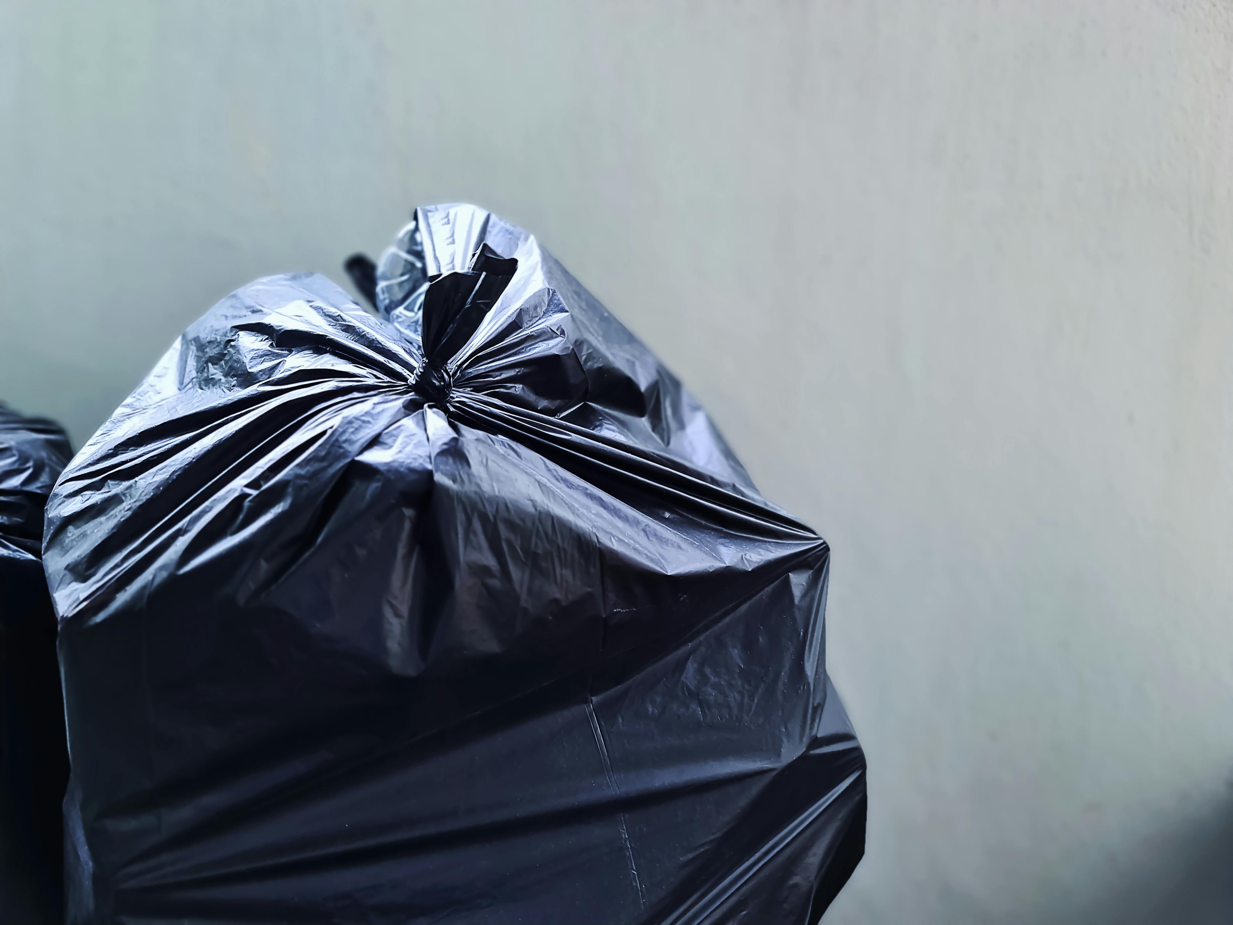 Sac en plastique noir près d'un mur en béton | Source : Pexels