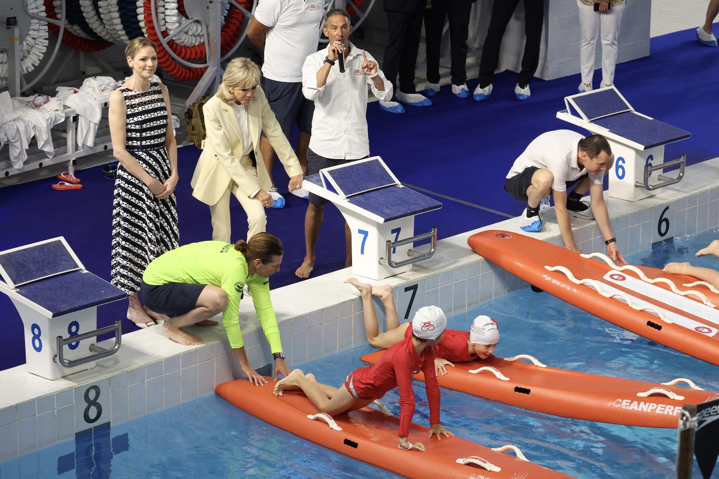 La première dame de France Brigitte Macron (3e G) et la princesse Charlène de Monaco (G) assistent à la démonstration "Sécurité aquatique" lors d'une visite au "Centre nautique Albert II", dans le cadre d'un événement organisé par la Fondation Princesse Charlène, à Monaco, le 8 juin 2025. I Source : Getty Images